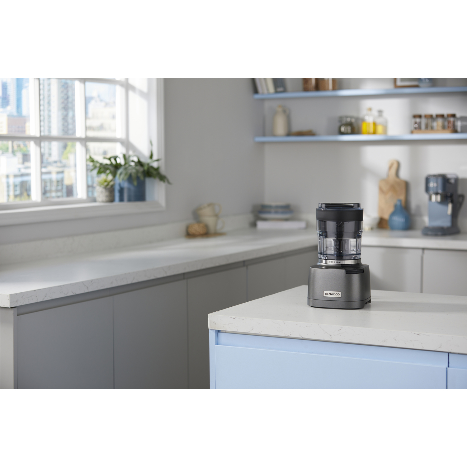 Een keuken met een blender op het aanrecht. Er is een raam op de achtergrond.