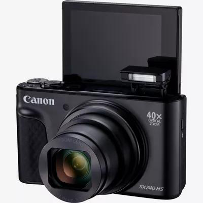 Schwarze Canon Kamera mit ausgefahrenem Objektiv, hochgeklapptem Bildschirm und Blitz.