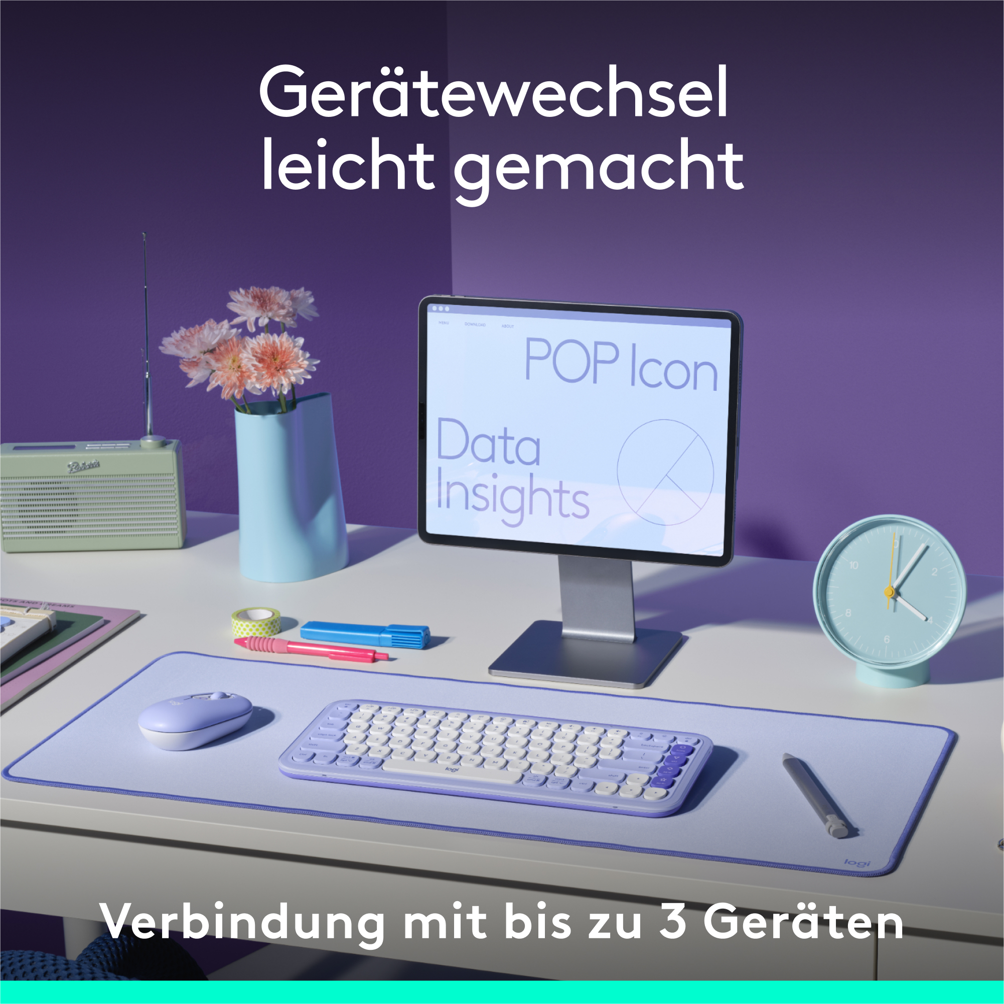 Ein Schreibtisch-Setup: ein Tablet, eine Tastatur und eine Maus. Blumen und eine Uhr. Lila und weiß.