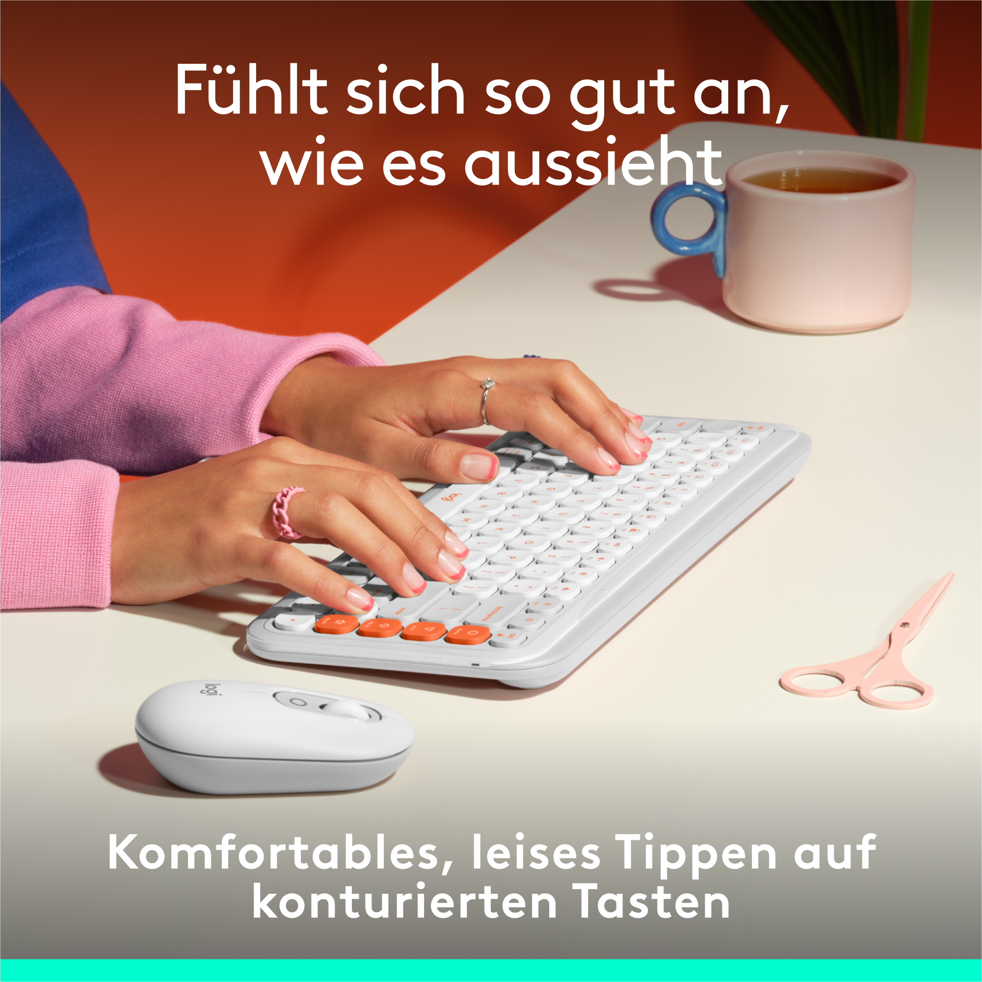 Hände tippen auf einer weißen Tastatur mit orangenen Tasten, Maus und rosa Schere.