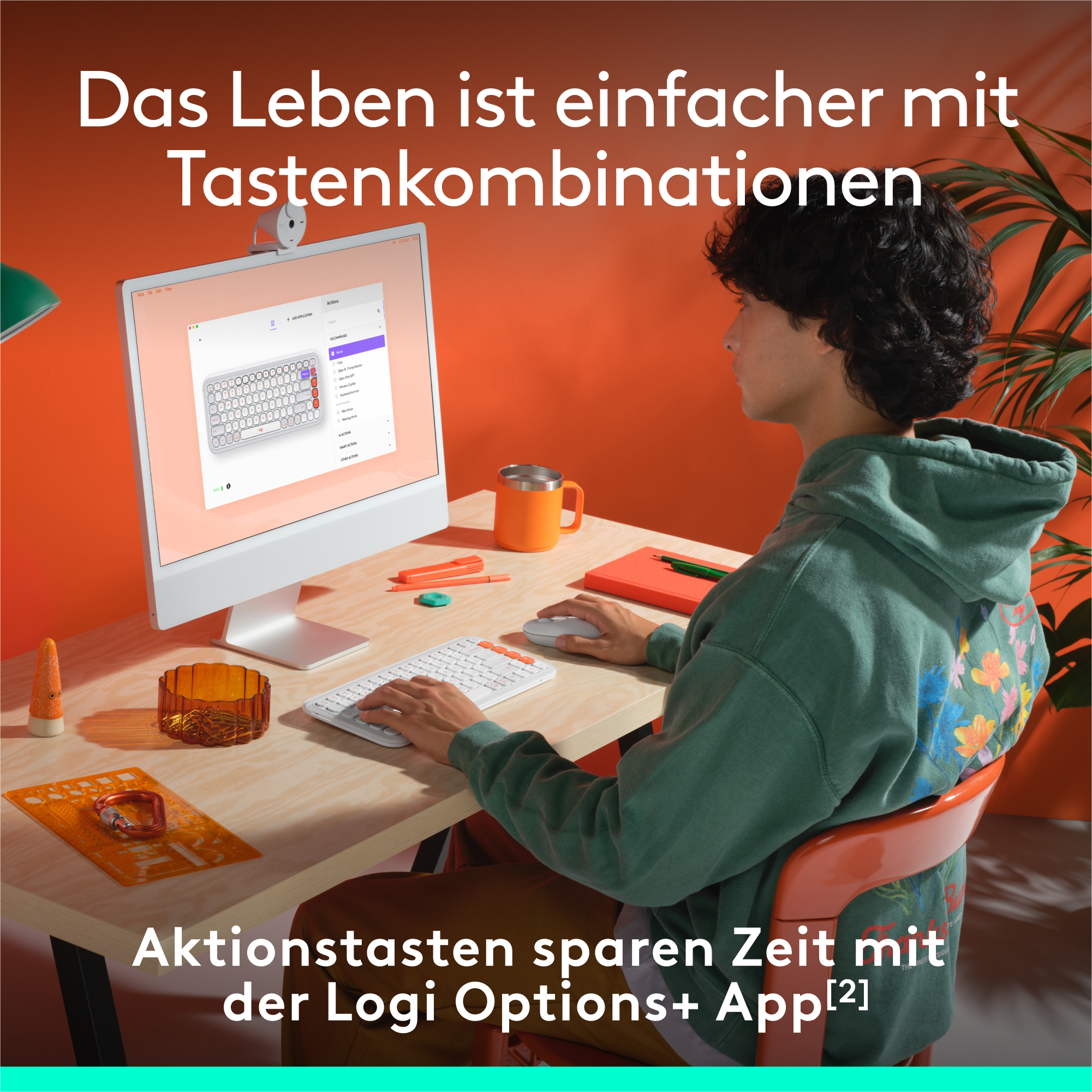 Ein Mann benutzt einen Computer mit weißer Tastatur und Monitor mit Text.