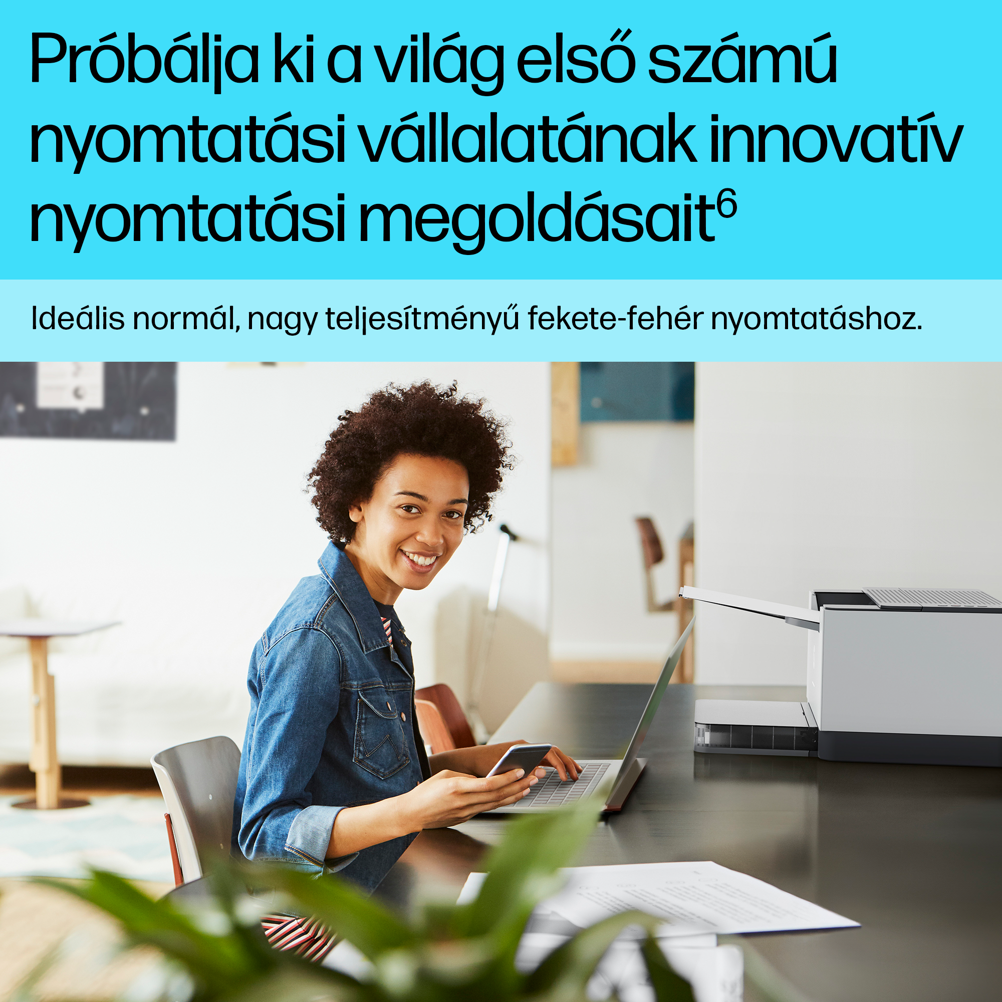 Nő mosolyog, miközben telefont tart és laptopot használ.
