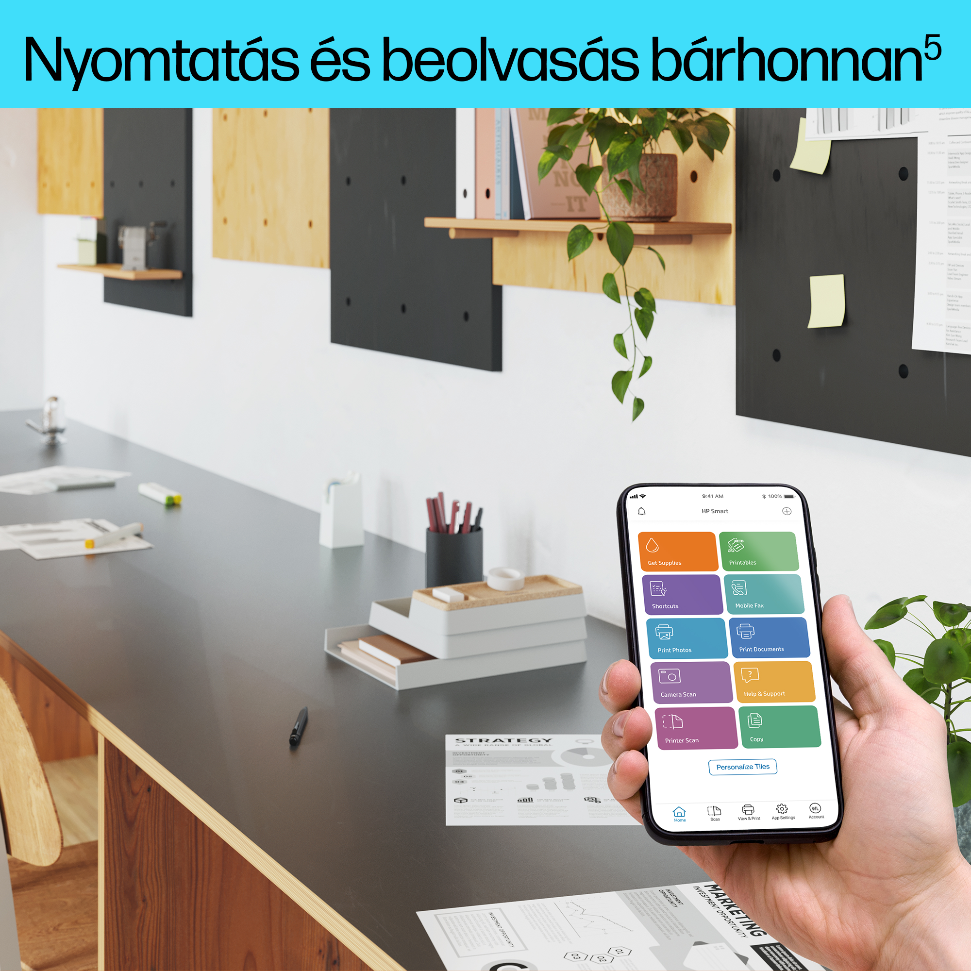 Személy, aki egy telefont tart egy alkalmazással, asztal papírokkal, és irodai háttér.