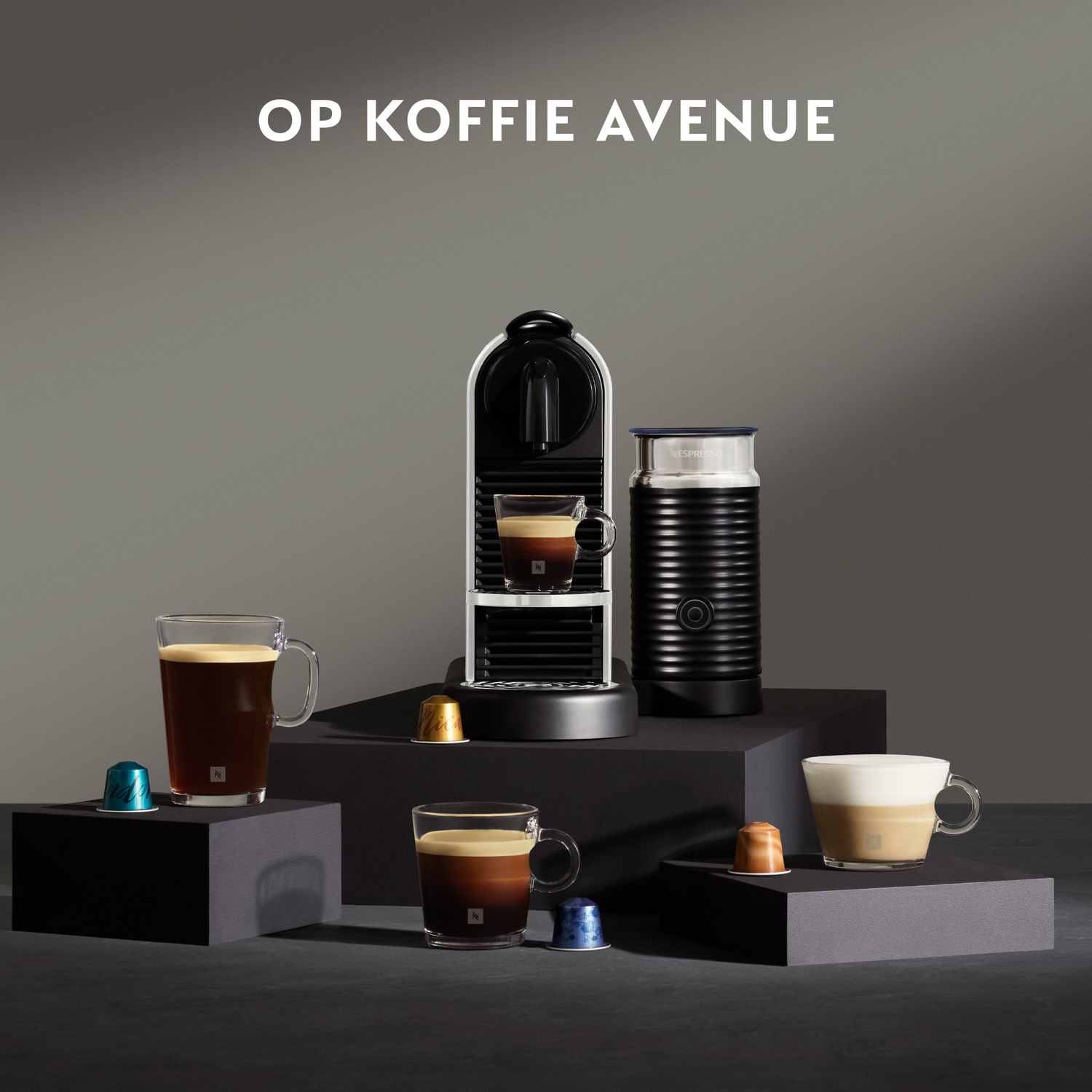 Coffee machine and accessories arranged on black platforms.