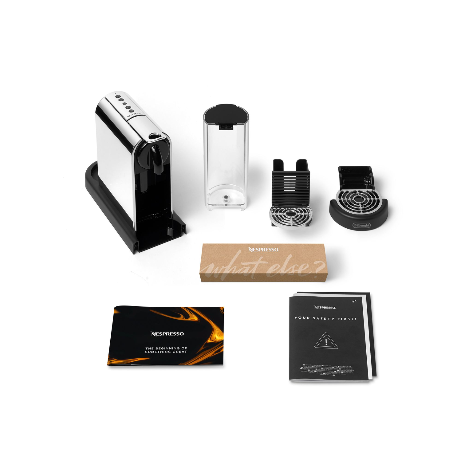 Nespresso machine components arranged on a white surface, including the machine and accessories.