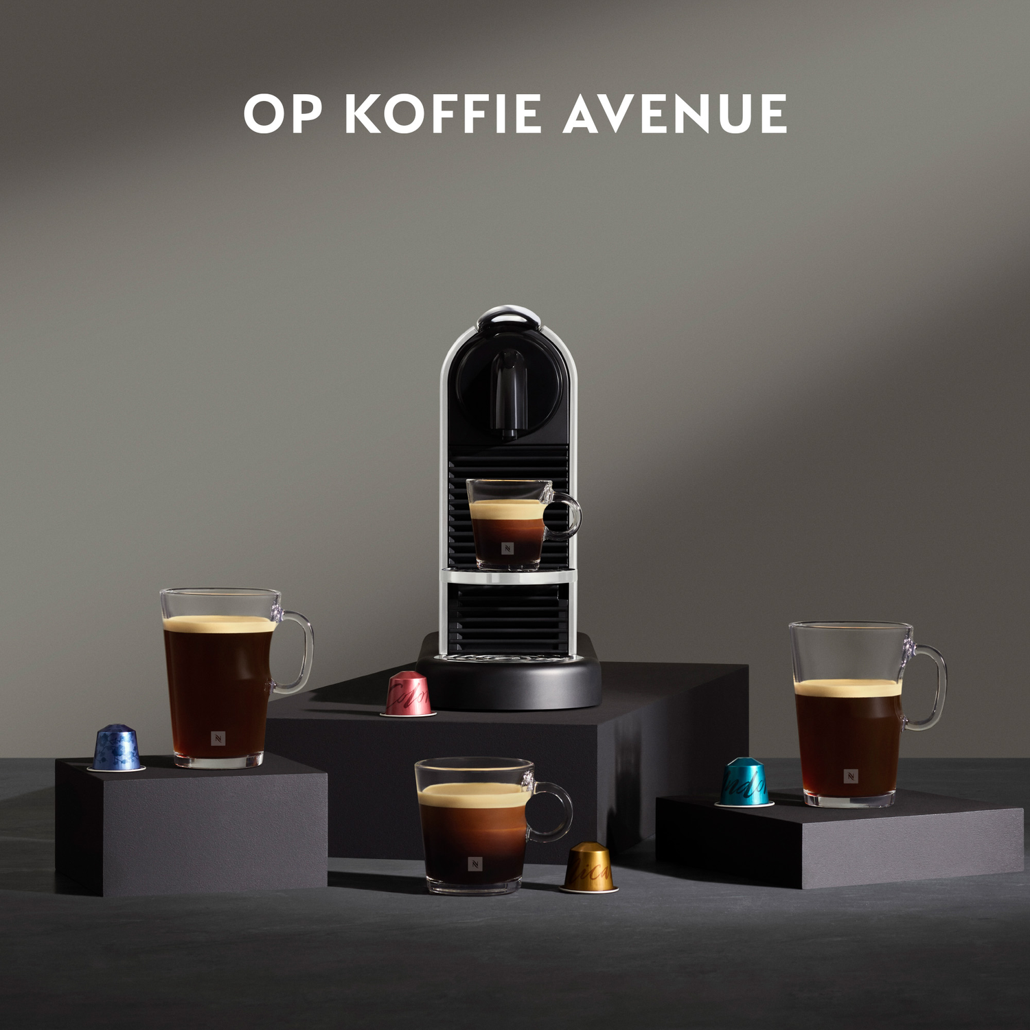 Nespresso coffee machine with three cups of coffee. Capsules on the side. Dark background.