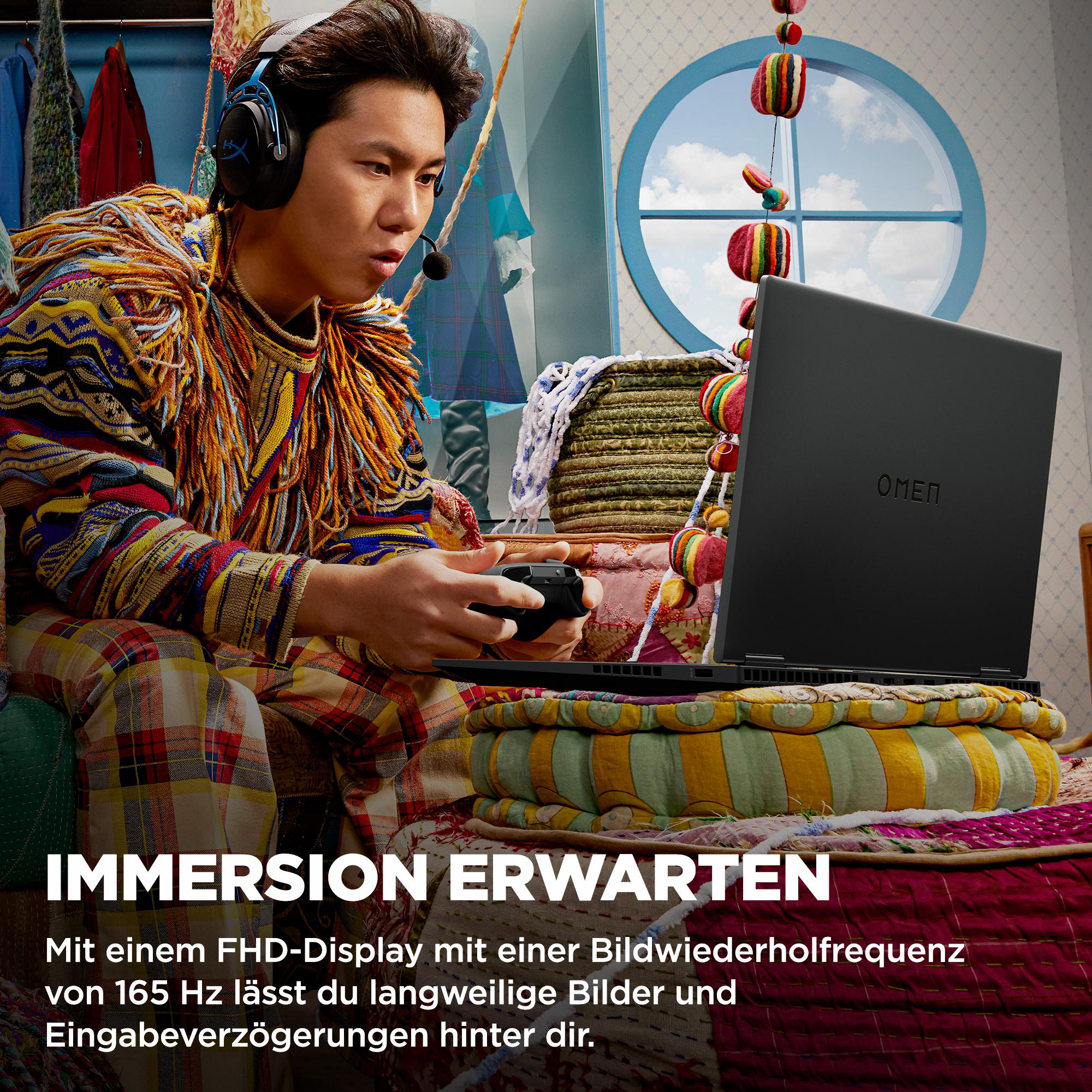 Mann mit Headset hält Controller und spielt auf einem schwarzen Laptop.