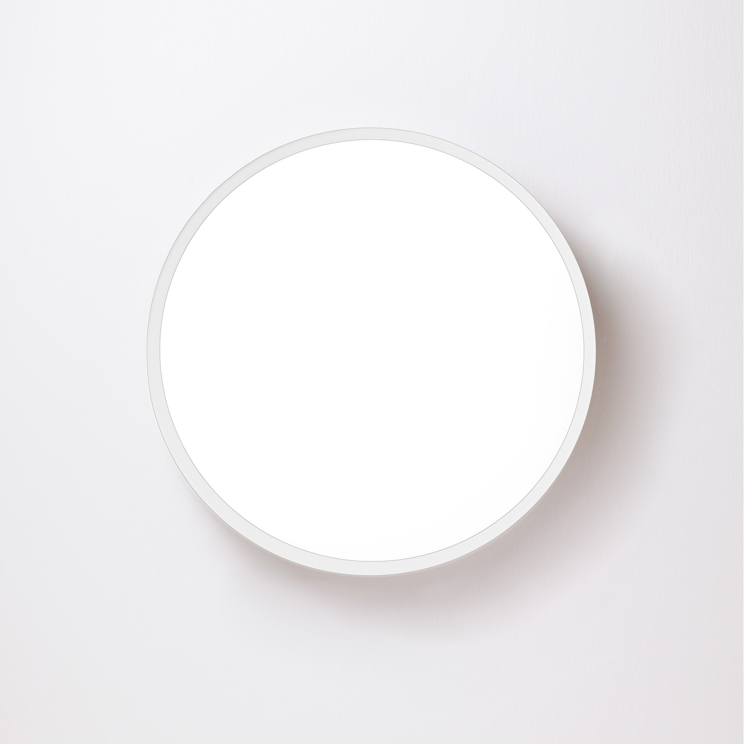 Un apparecchio di illuminazione circolare bianco montato su una parete bianca.