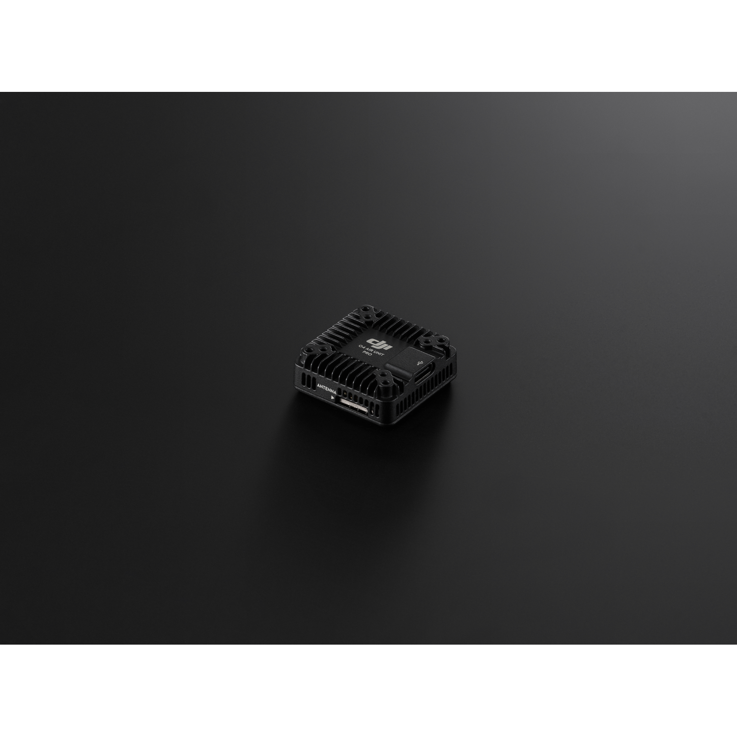 Black drone component on a black surface. DJI logo is visible.