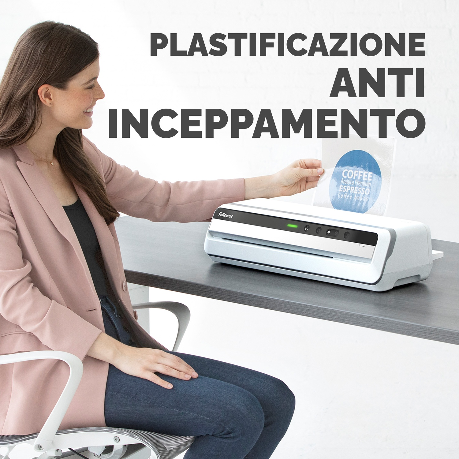 Una donna utilizza una plastificatrice bianca, con testo anti-inceppamento, su un tavolo grigio.