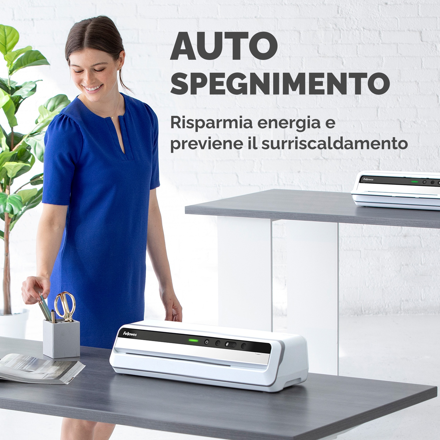 Donna in abito blu accanto a una plastificatrice bianca e grigia.