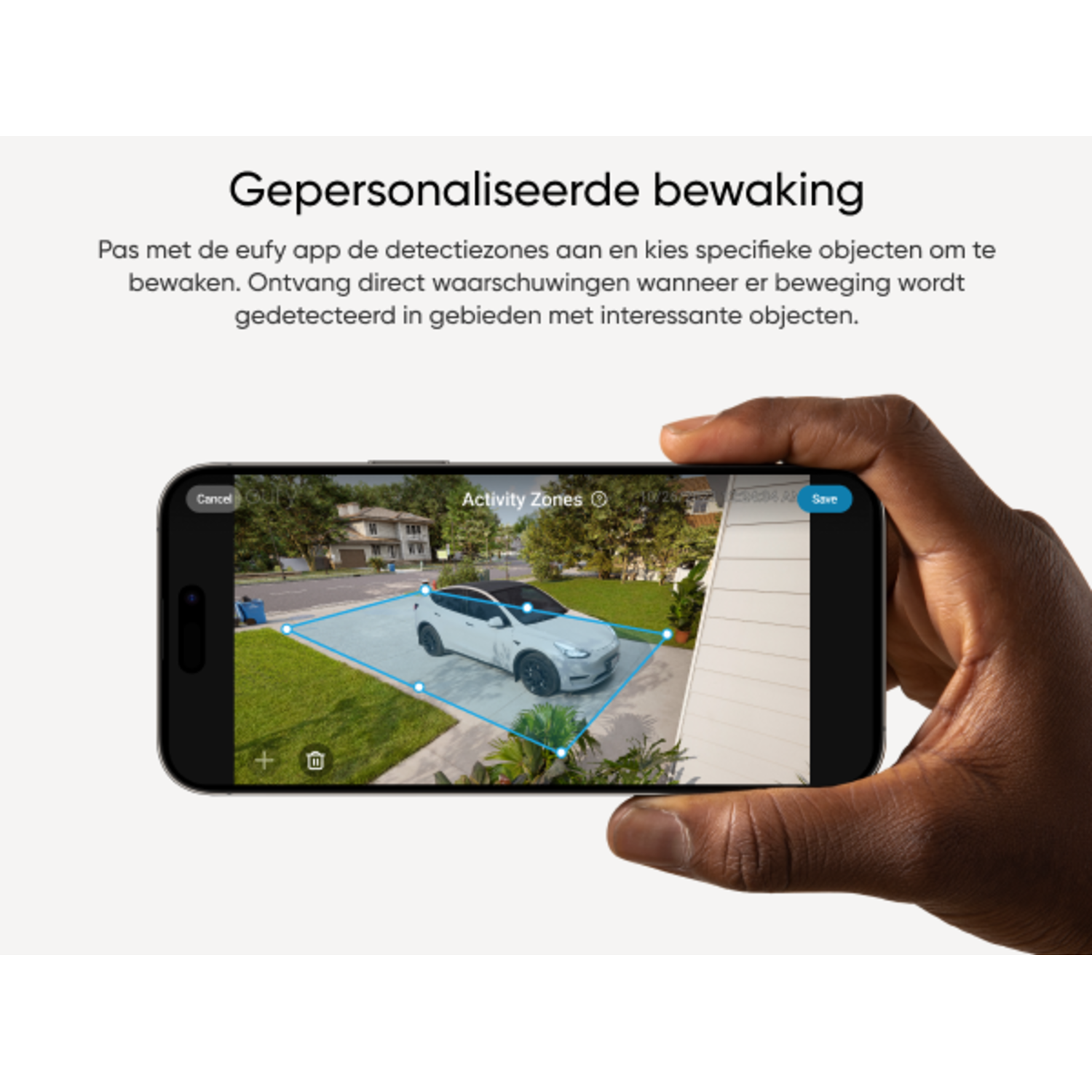 Een persoon die een telefoon vasthoudt met een smart home-app die een auto op de oprit laat zien.
