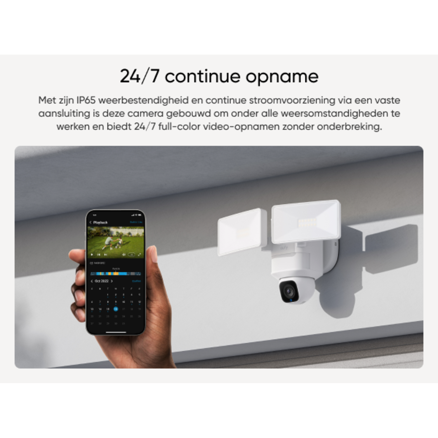 Een beveiligingscamera aan een muur gemonteerd, met een mobiele telefoon die de weergave van de camera toont.