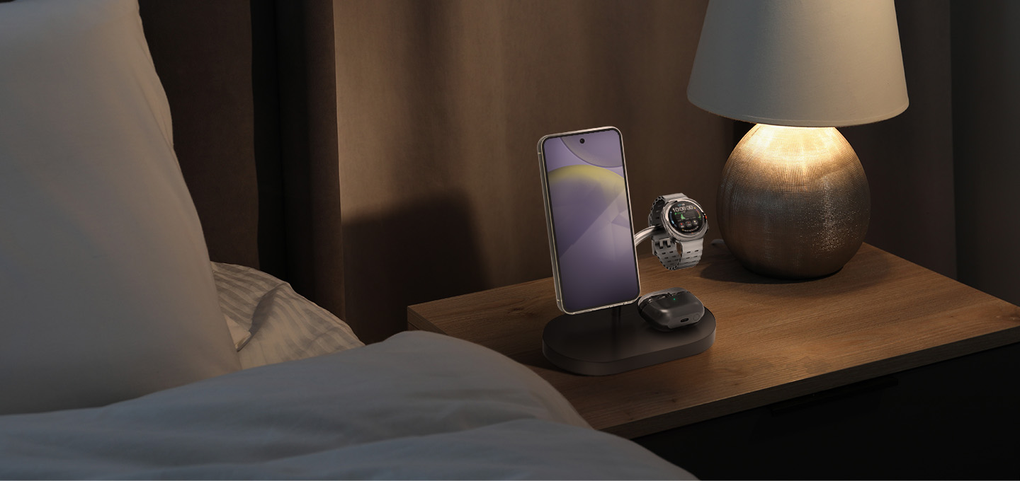Un telefono e un orologio su un comodino in carica.