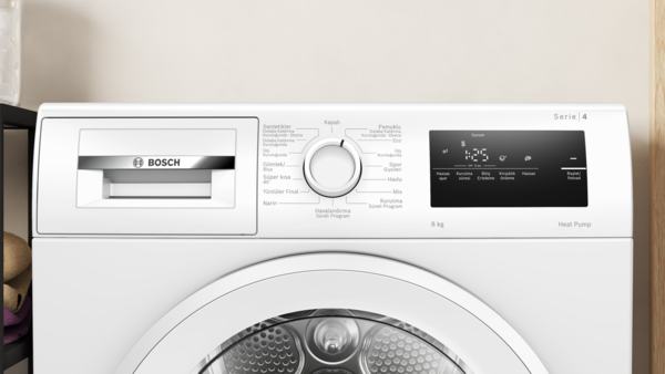 Beyaz çamaşır makinesi, kontrol paneli görünür durumda. Üzerinde Bosch logosu var.