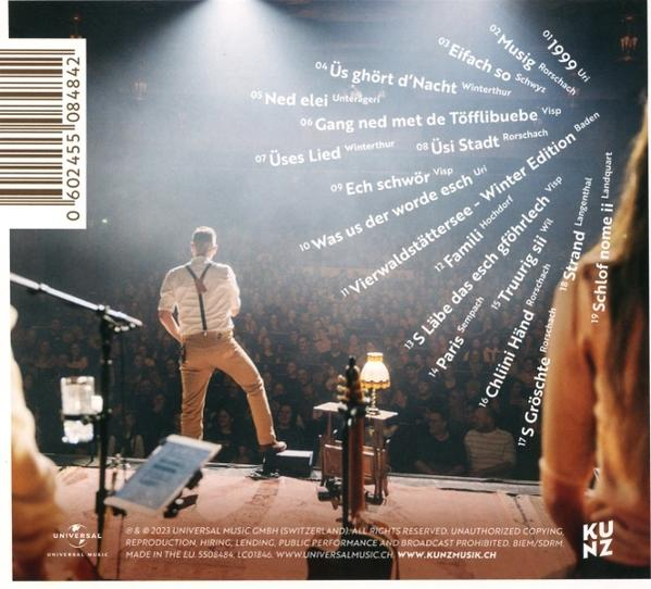 Die Rückseite einer CD-Hülle mit einer Band, die auf der Bühne auftritt, mit Songtiteln.