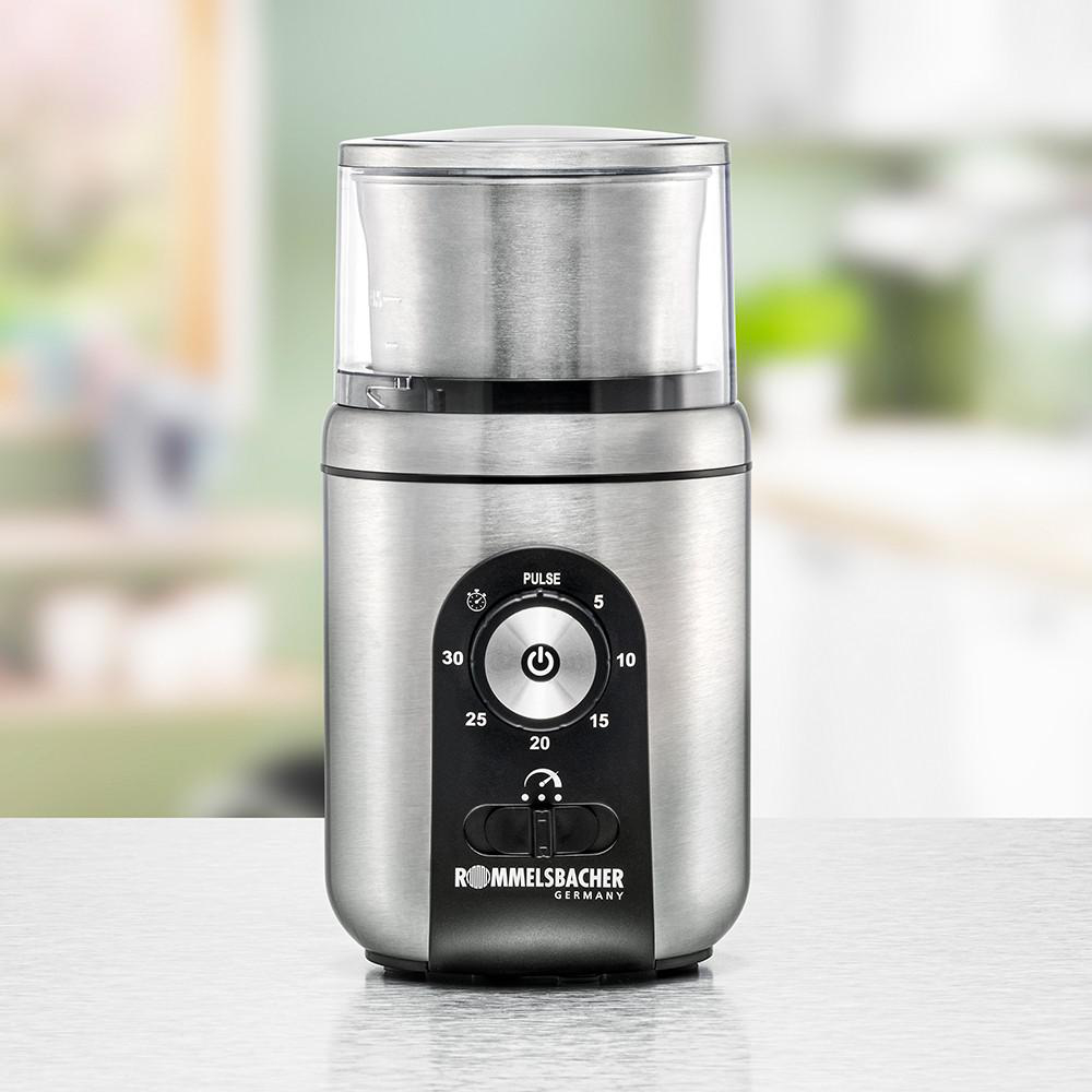 Eine Kaffeemühle aus Edelstahl mit Timer und Ein-/Aus-Taste. Der Hintergrund ist unscharf.
