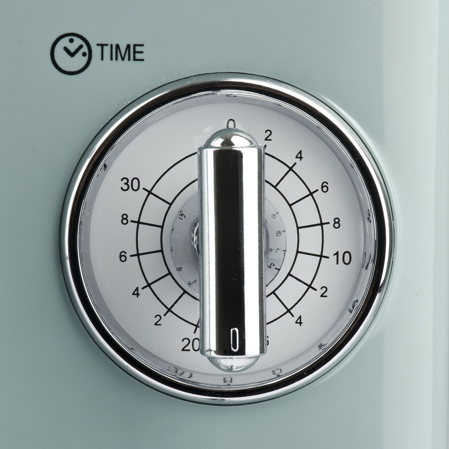 Primo piano di un quadrante del timer, con una maniglia argentata, su uno sfondo azzurro. L'ora è impostata su '0'.