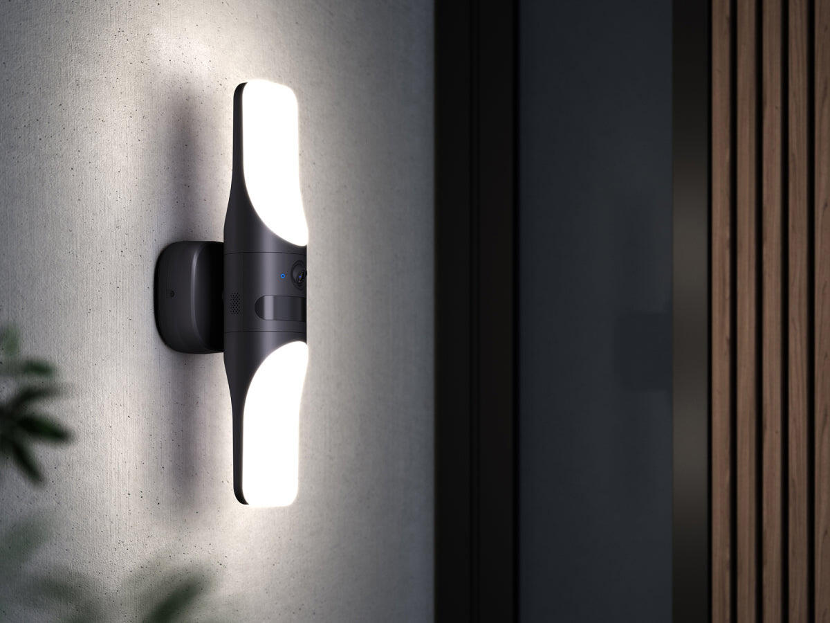 Czarna lampa ścienna na teksturowanej ścianie, emitująca światło. Ma elegancki, nowoczesny design.