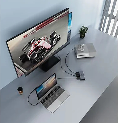 Konfiguracja komputera: laptop, monitor i konsola do gier podłączone przez hub.