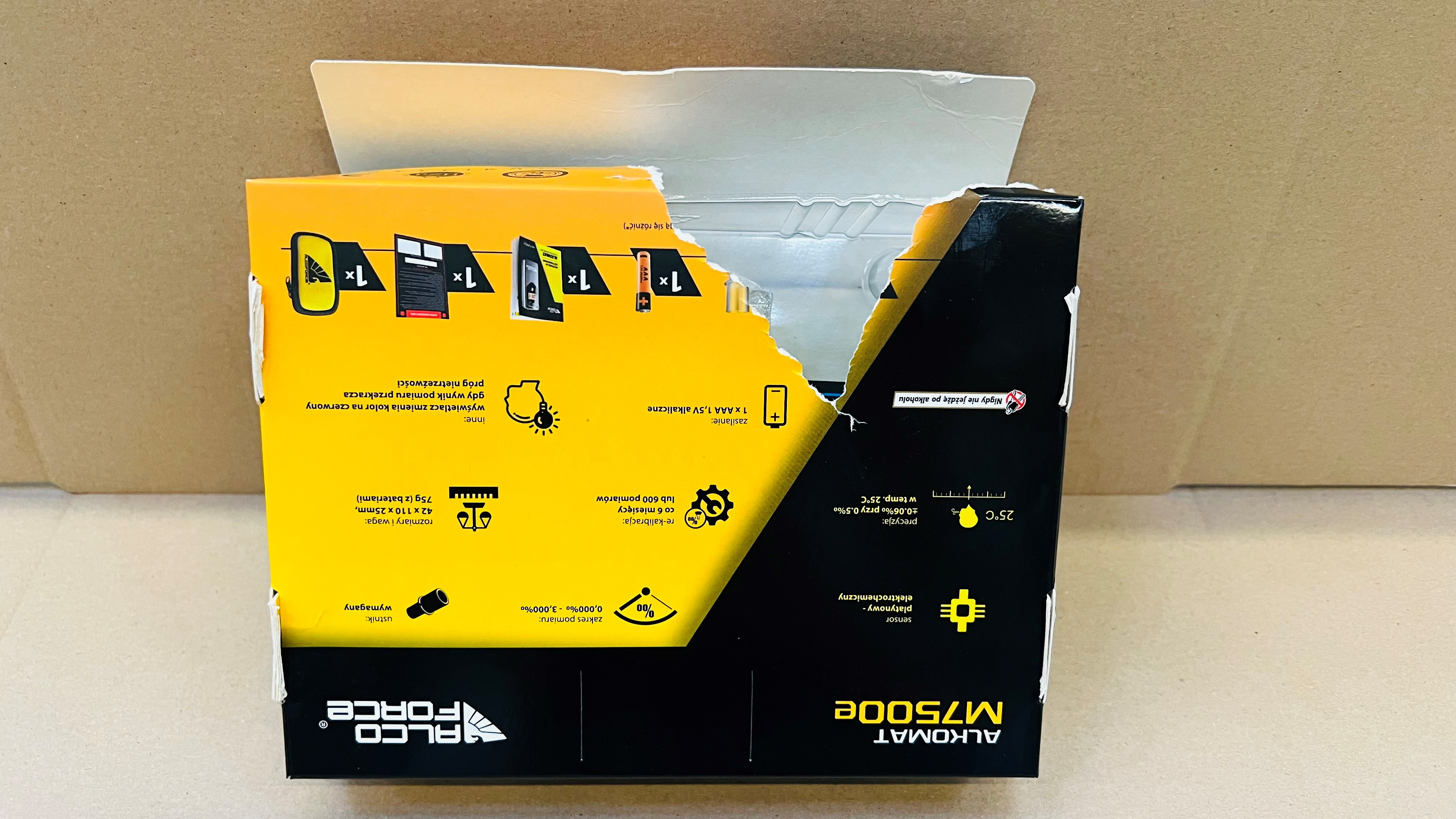 Częściowo otwarte pudełko z informacjami o produkcie i logo.