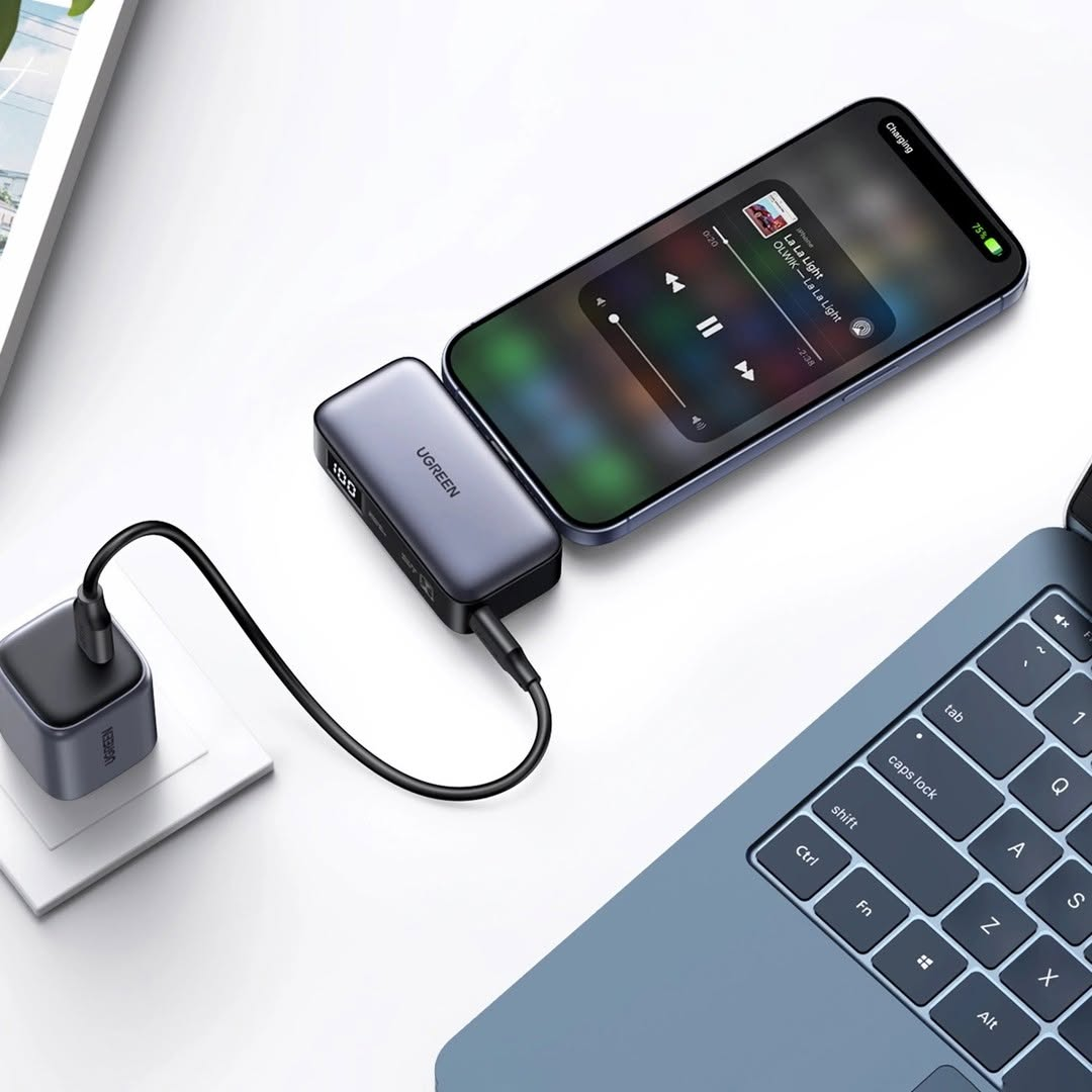 Bir telefon, bir güç bankası ve şarj cihazı ile şarj oluyor. Telefon bir müzik uygulaması görüntülüyor.