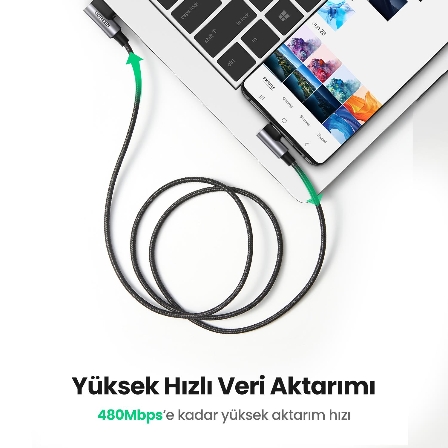 Bir şarj kablosuyla bir telefona bağlı bir dizüstü bilgisayar.