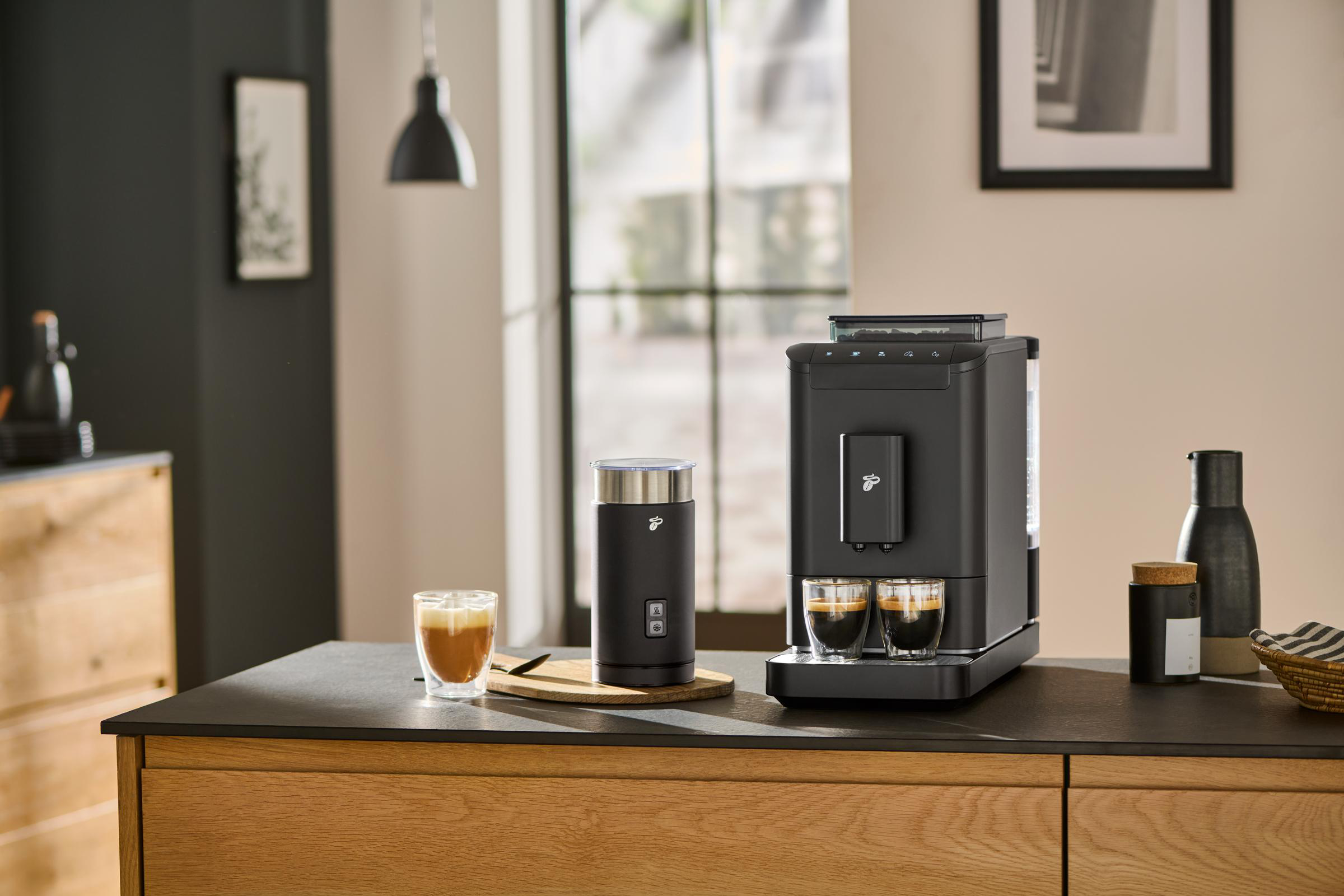 Eine schwarze Kaffeemaschine mit Zubehör auf einer Theke.