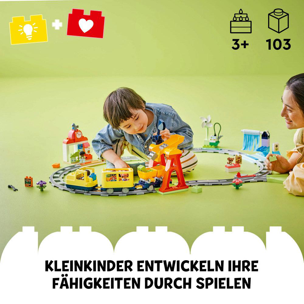 Kind spielt mit einem Spielzeugeisenbahn-Set, eine Frau schaut zu.