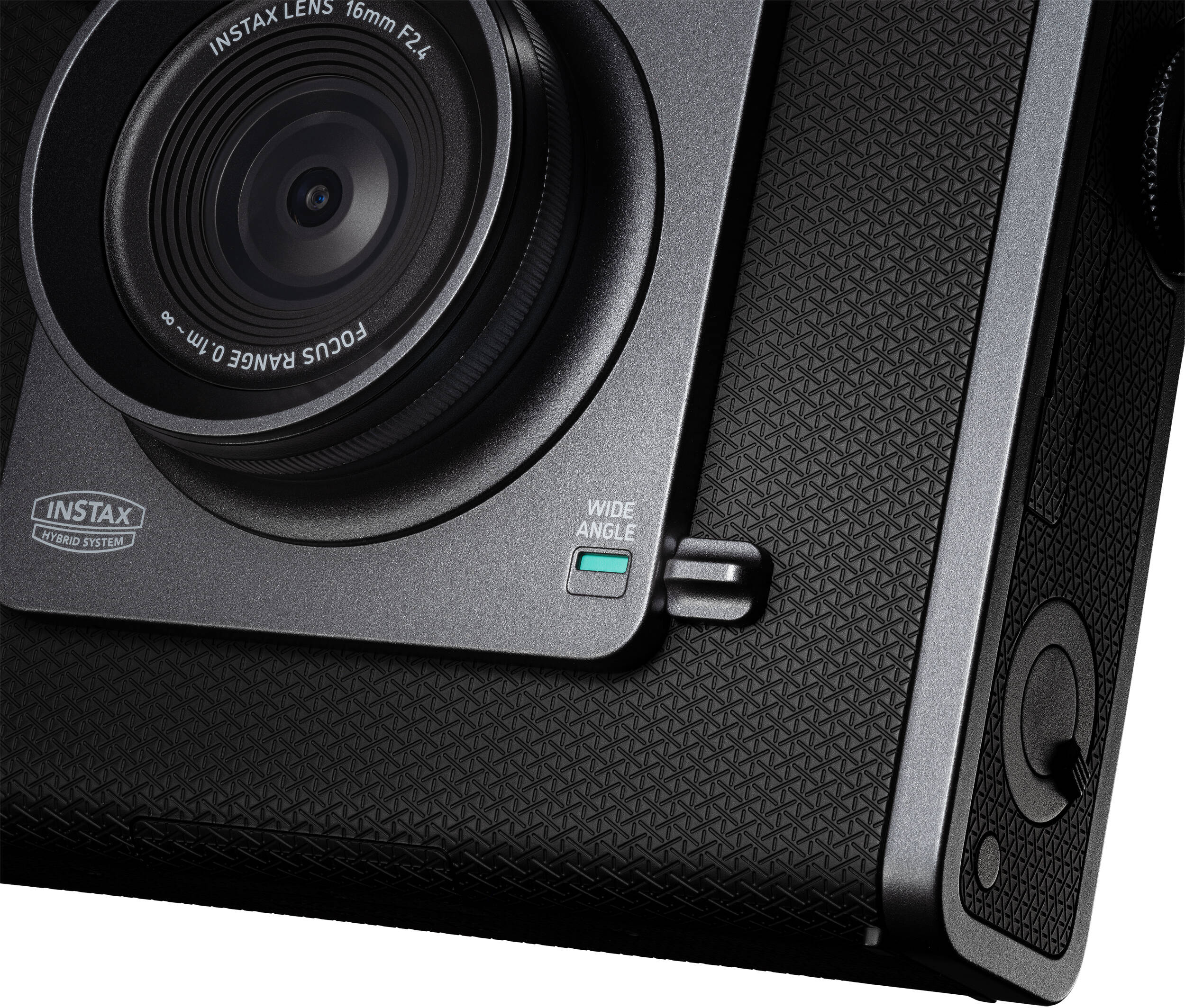 Primo piano di una fotocamera istantanea nera e grigia, con obiettivo grandangolare visibile.