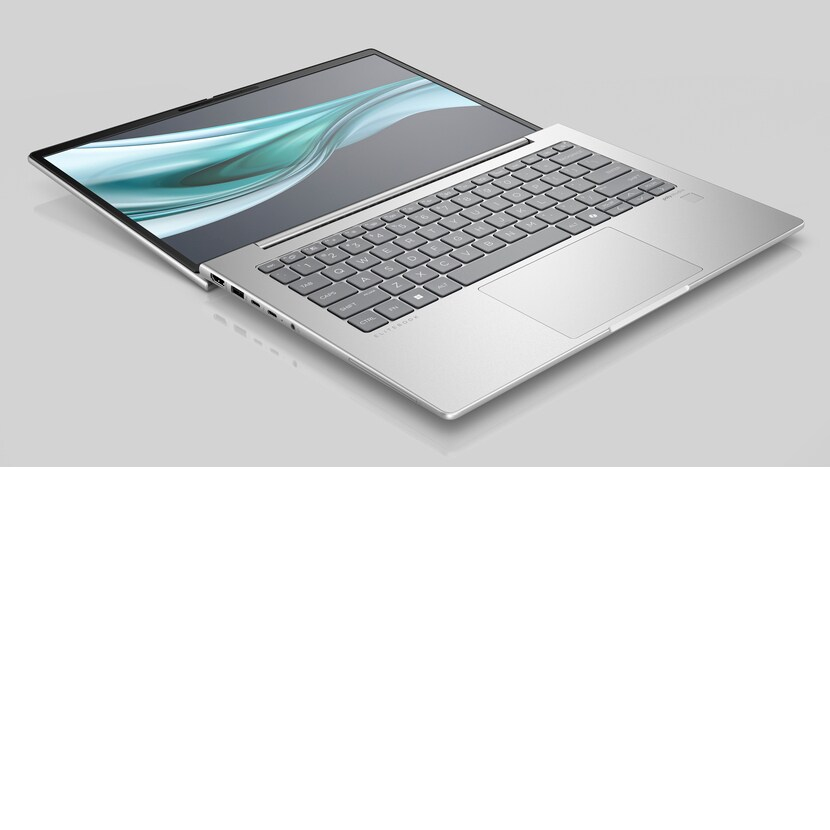 Ein silberner Laptop mit hochgeklapptem Bildschirm auf einer grauen Oberfläche, Tastatur und Touchpad zeigend.