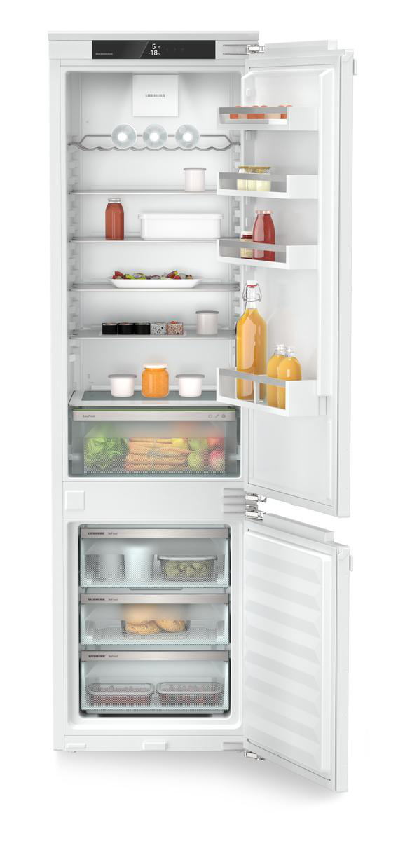 Ein offener Kühlschrank mit Regalen voller Essen und Getränke. Gemüse und Schubladen sind sichtbar.