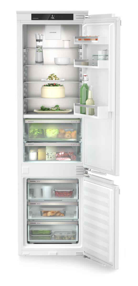 Kühlschrank-Innenraum. Regale mit Lebensmitteln und Getränken. Enthält Schubladen. Weißes Interieur, offene Tür.