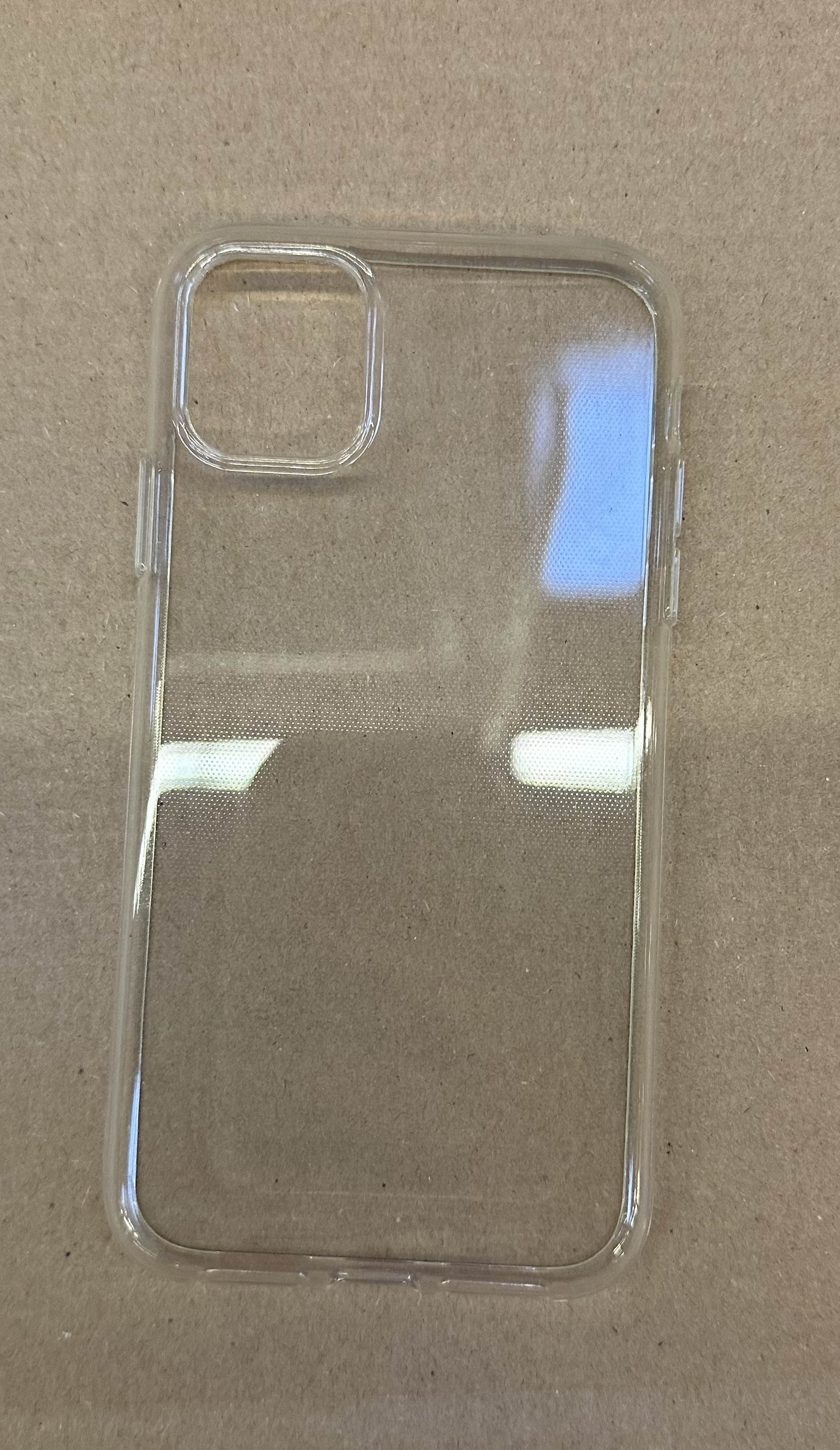 Przezroczyste etui na telefon na brązowej powierzchni.