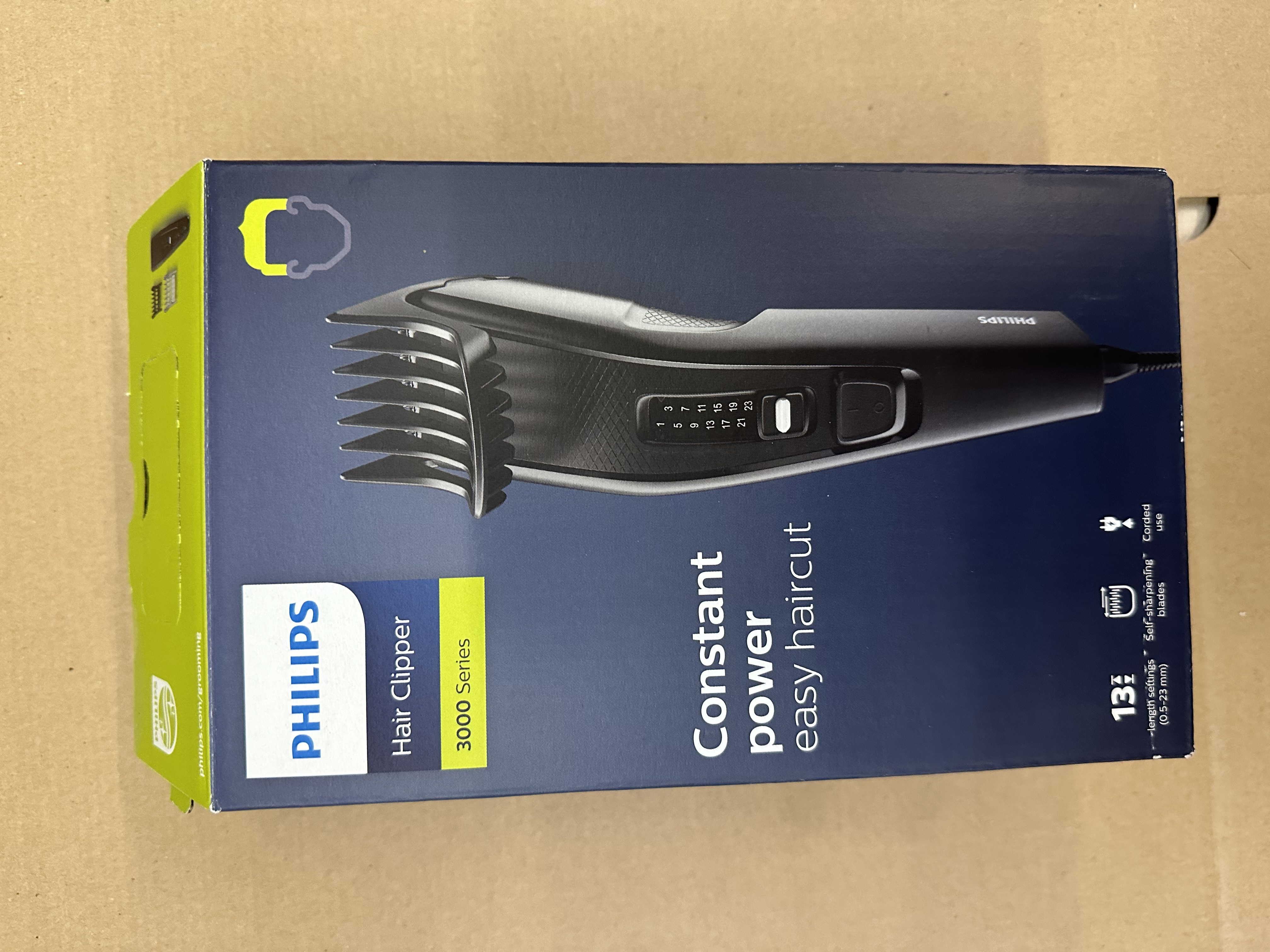Pudełko maszynki do strzyżenia włosów Philips, z czarną maszynką z przodu.