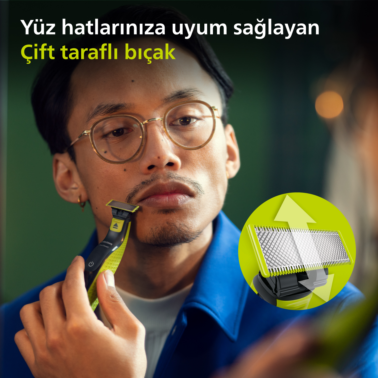 Adam yeşil ve siyah elektrikli tıraş makinesiyle tıraş oluyor.