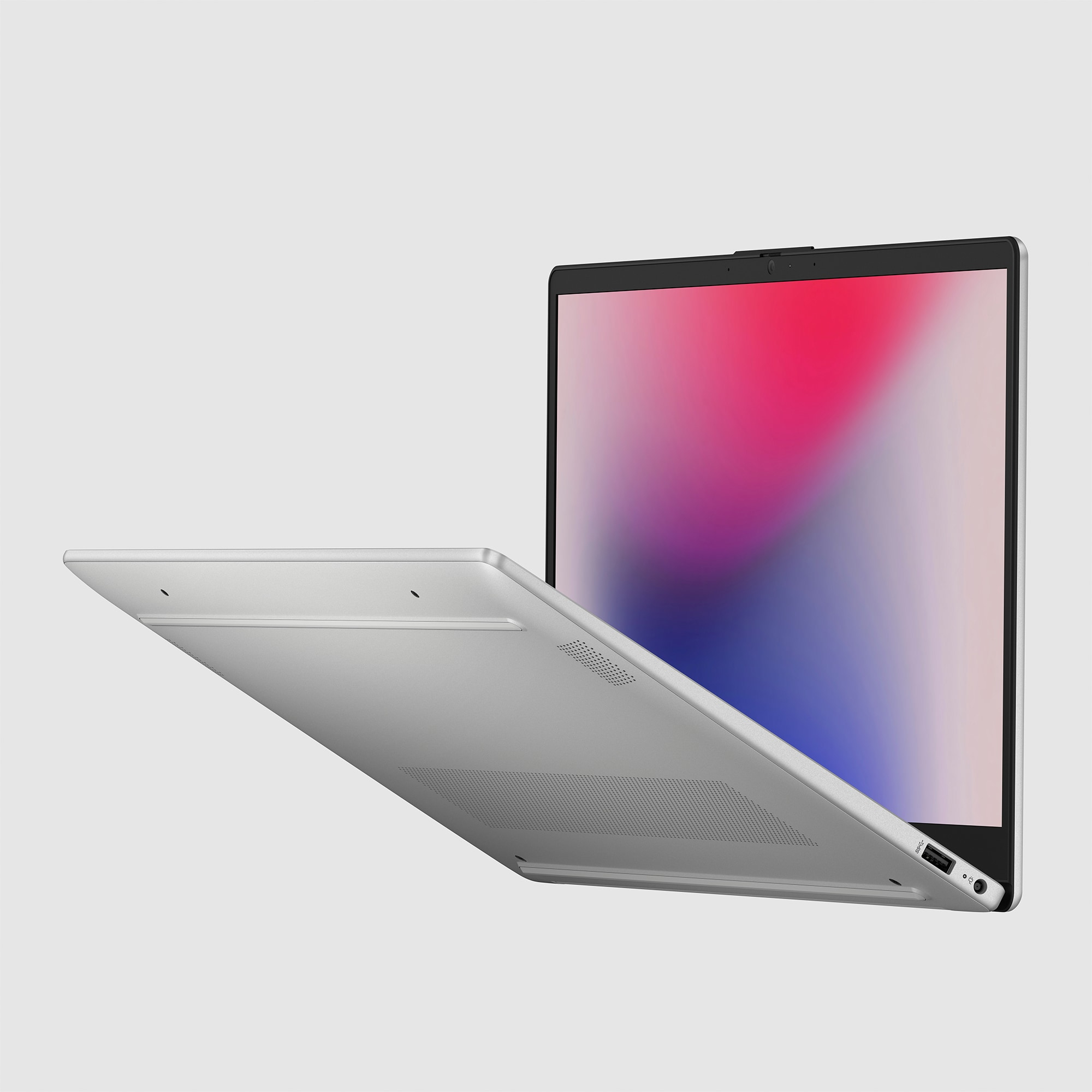 Una computadora portátil plateada con la pantalla abierta, que muestra un diseño abstracto y colorido.