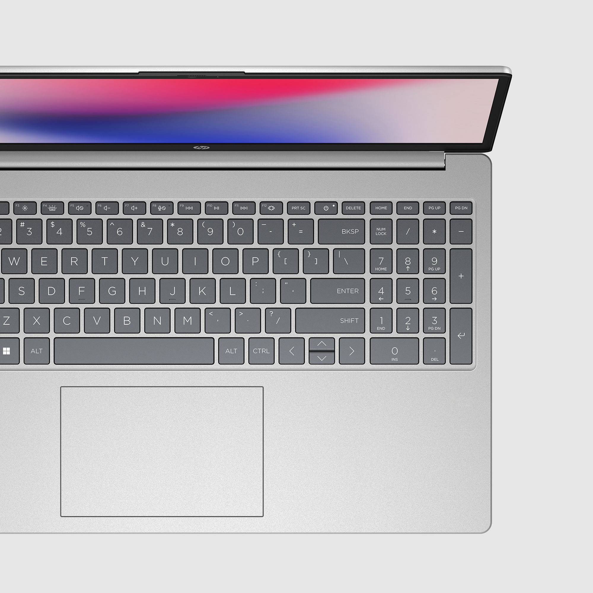 Primer plano del teclado del portátil: teclas, panel táctil y marco plateado.