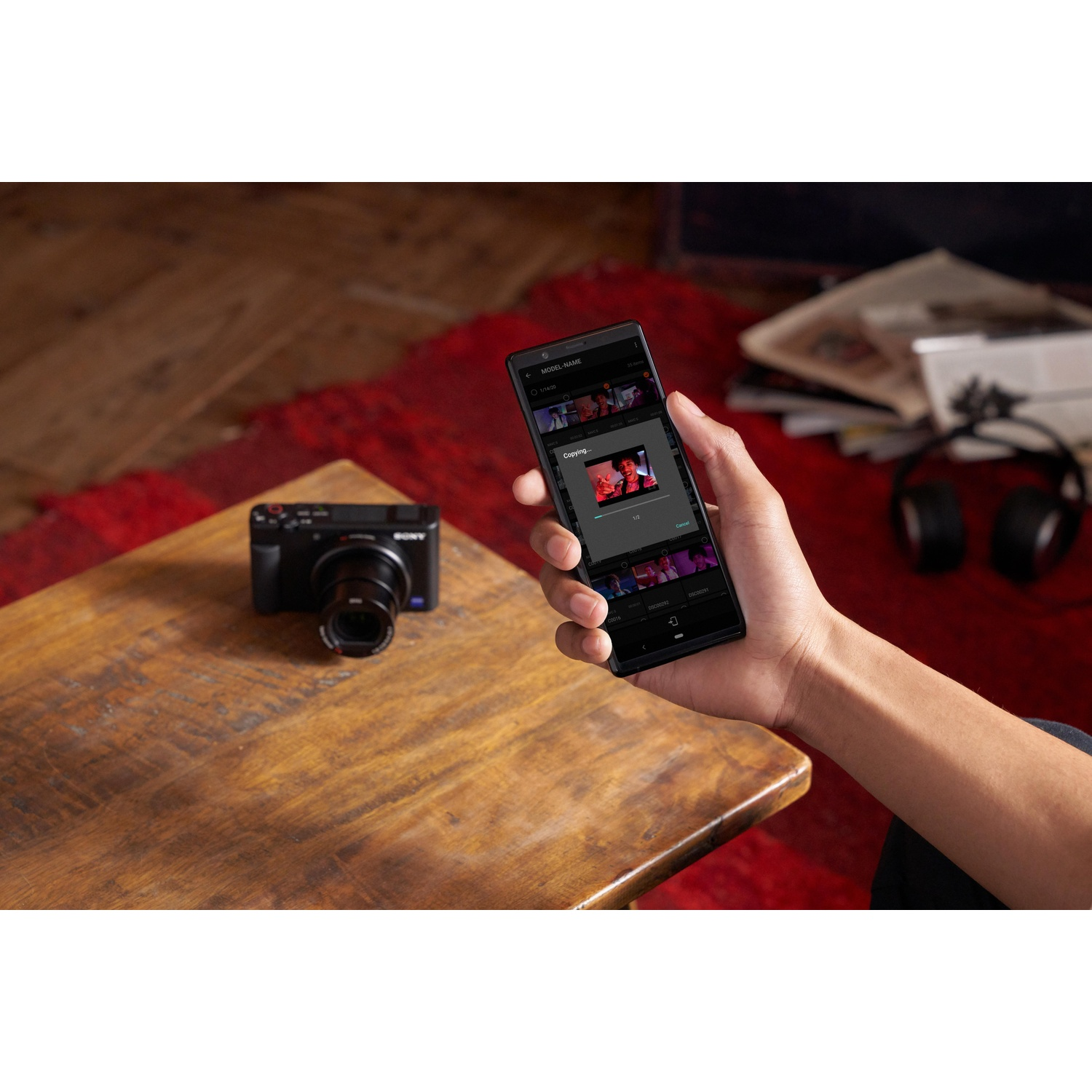 Mano che tiene un telefono con un'app musicale, fotocamera e tavolo nella scena.