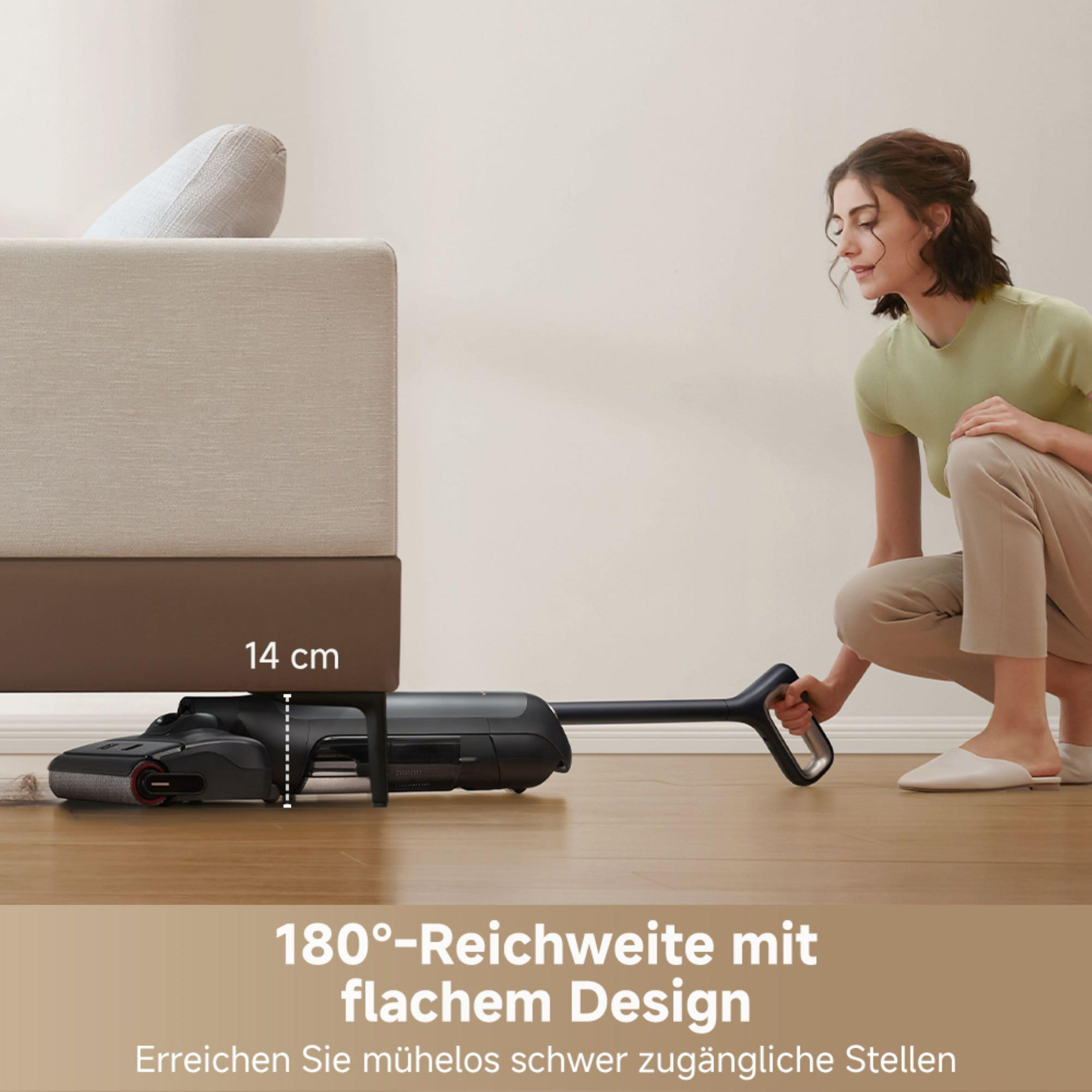 Frau benutzt Staubsauger unter Sofa. Zeigt niedriges Profil des Staubsaugers. Text: 180° Reichweite mit flachem Design.