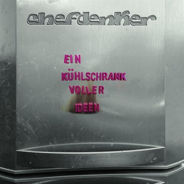 Kühlschranktür mit Text: 'Ein Kühlschrank voller Ideen' in rosa Buchstaben. Silberne Oberfläche.
