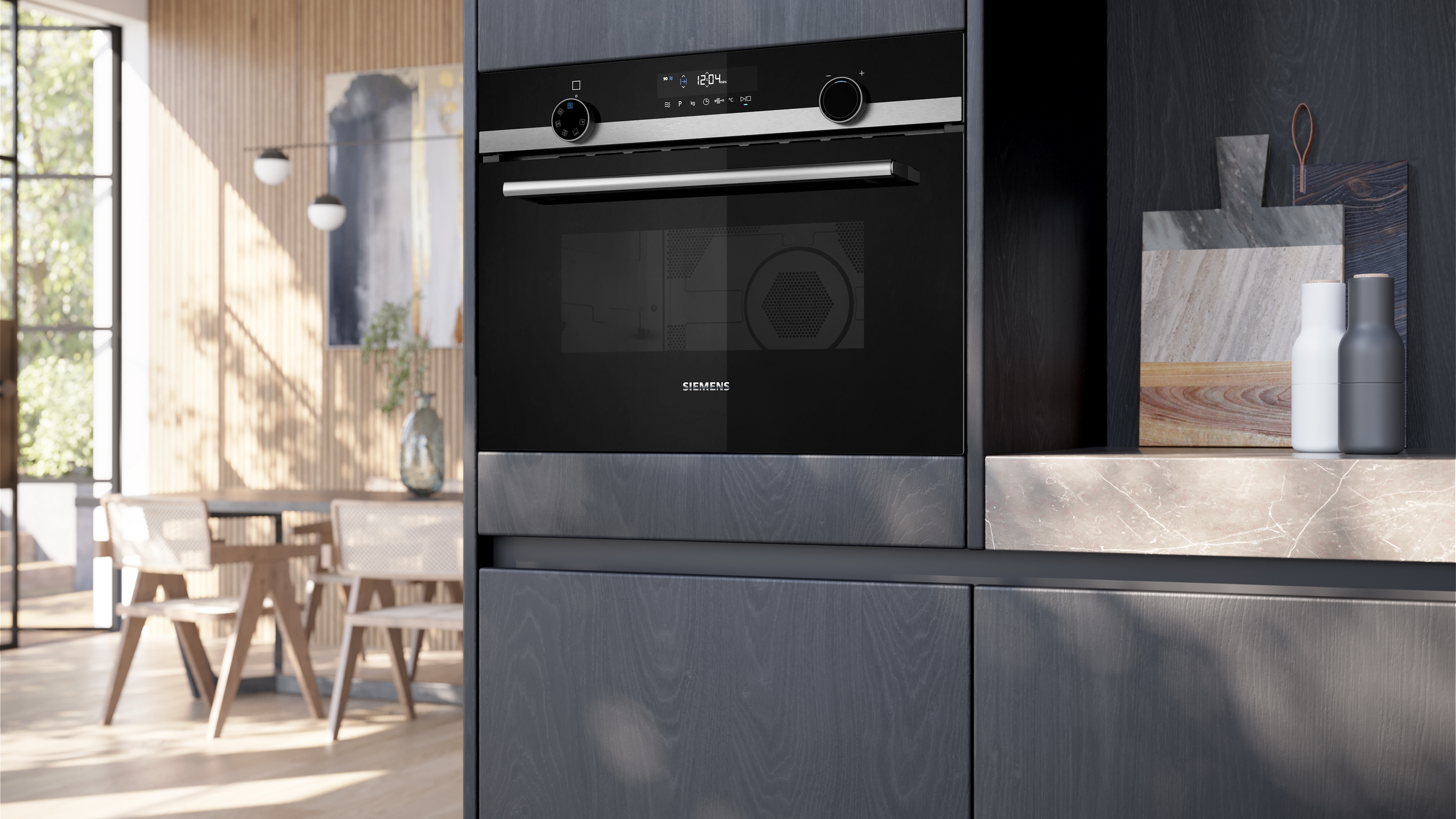 Eine moderne Küchenszene mit einem schwarzen Backofen, Holzschränken, Schneidebrettern und dekorativen Flaschen. Esstisch im Hintergrund.