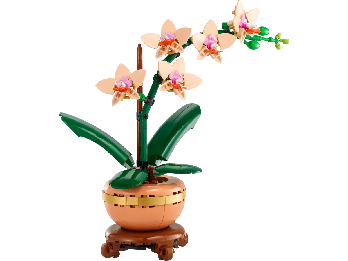 Model orchidei LEGO w brązowej doniczce, z zielonymi liśćmi i różowo-białymi kwiatami.