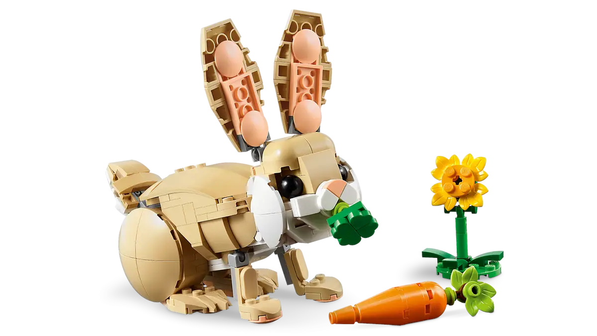 Model królika Lego z marchewką i kwiatkiem na białym tle.