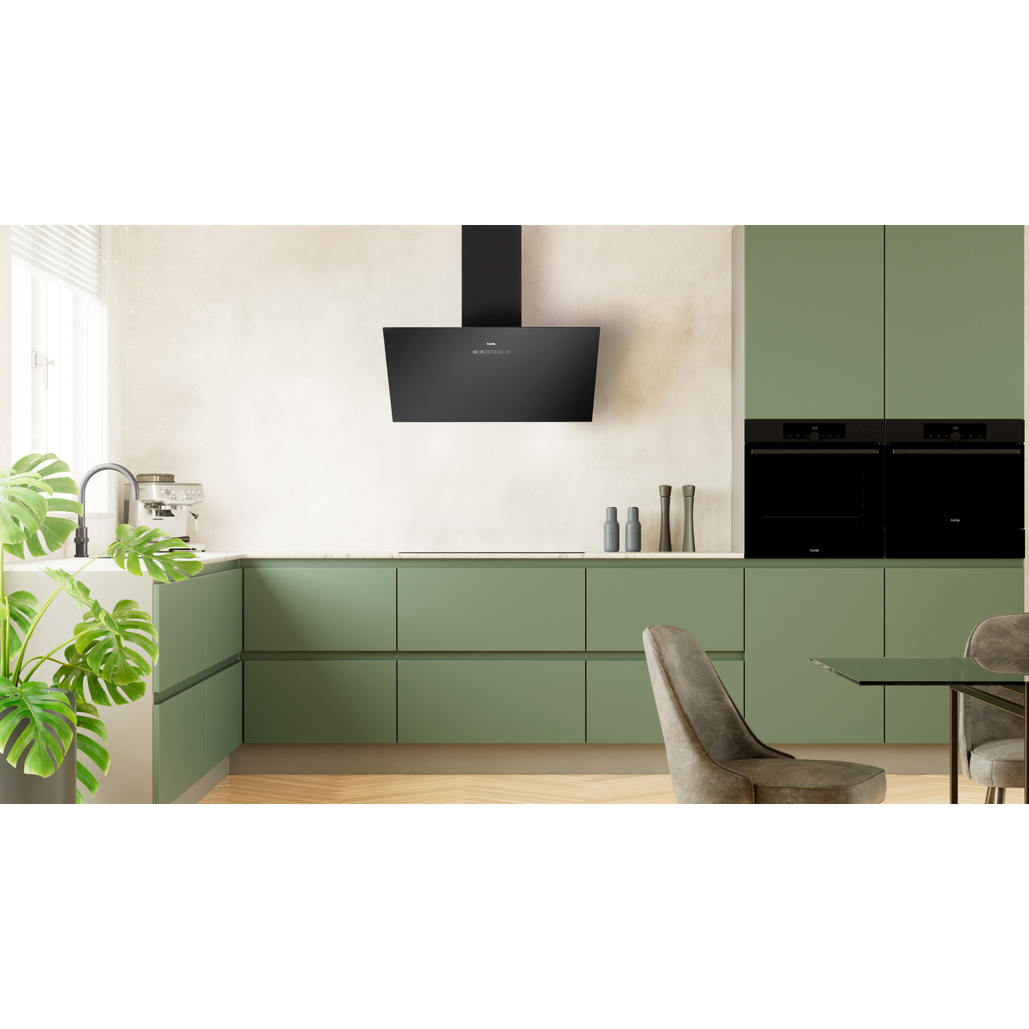 Keuken met groene kasten en een zwarte afzuigkap. Een moderne keuken met apparaten.