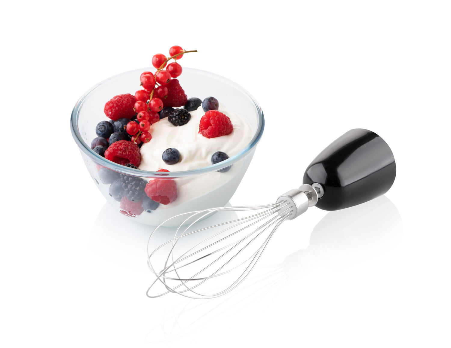 Egy üvegtál joghurt bogyós gyümölcsökkel és egy fekete botmixer habverővel.