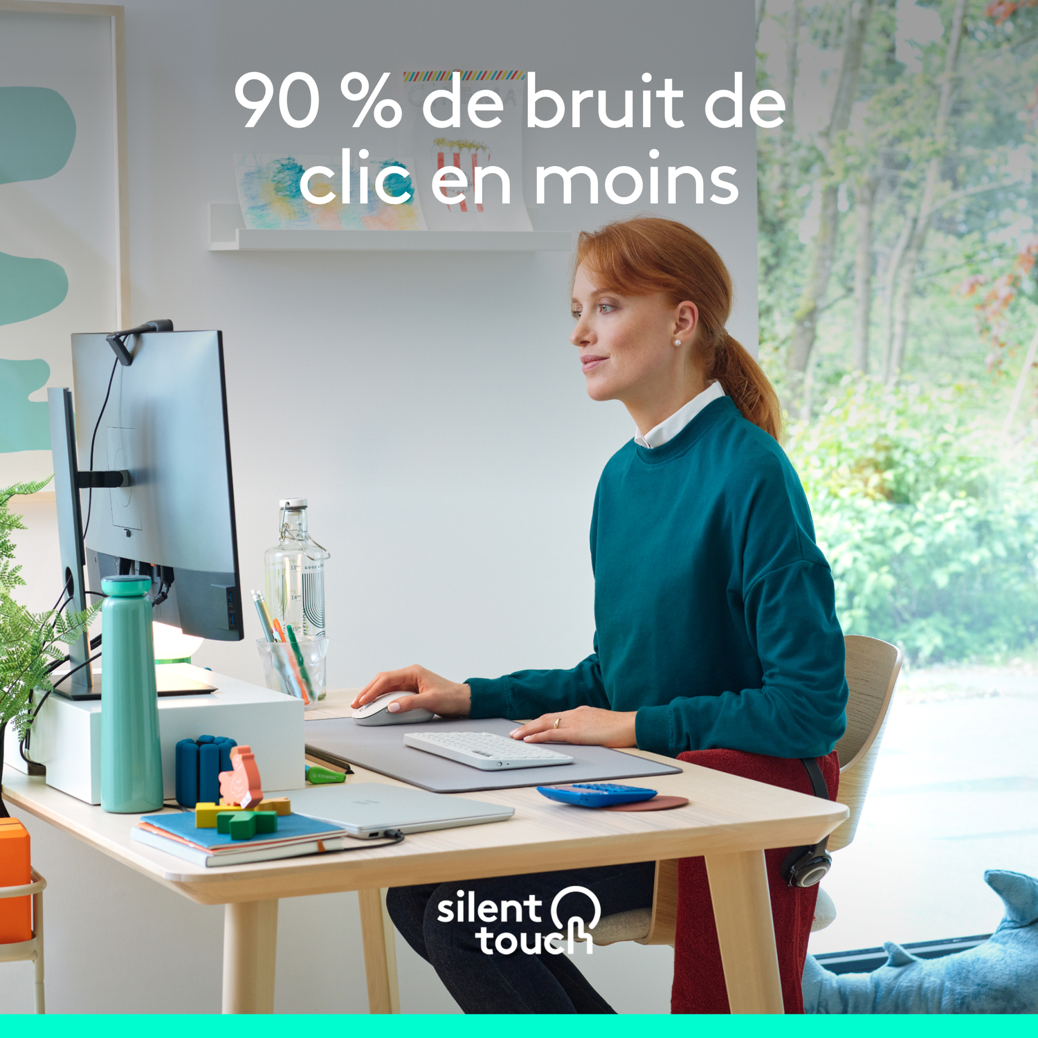 Femme à son bureau, utilisant la souris et le clavier. Moniteur, bouteille d'eau et blocs de bois visibles.