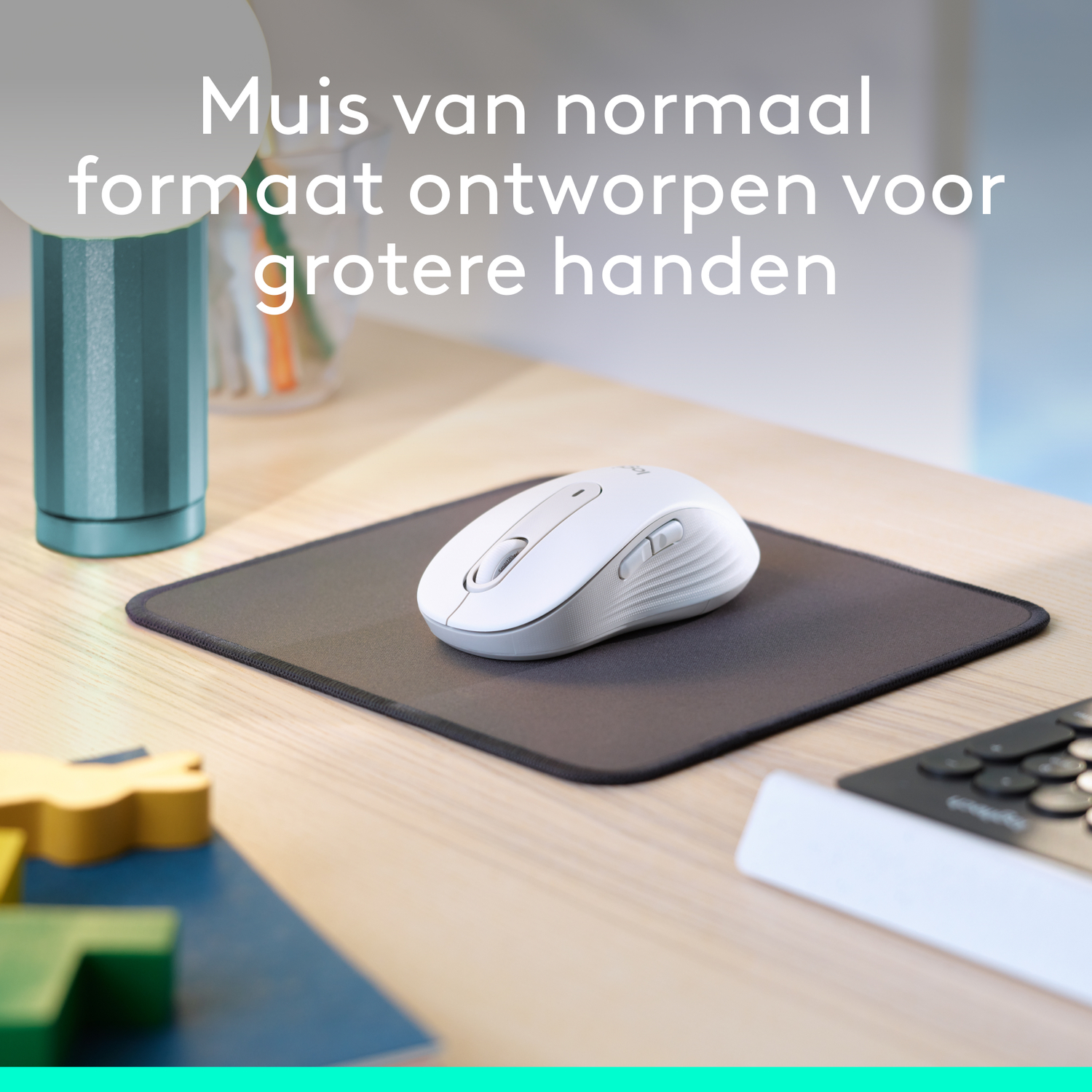 White mouse on a black mousepad on a light wooden desk.