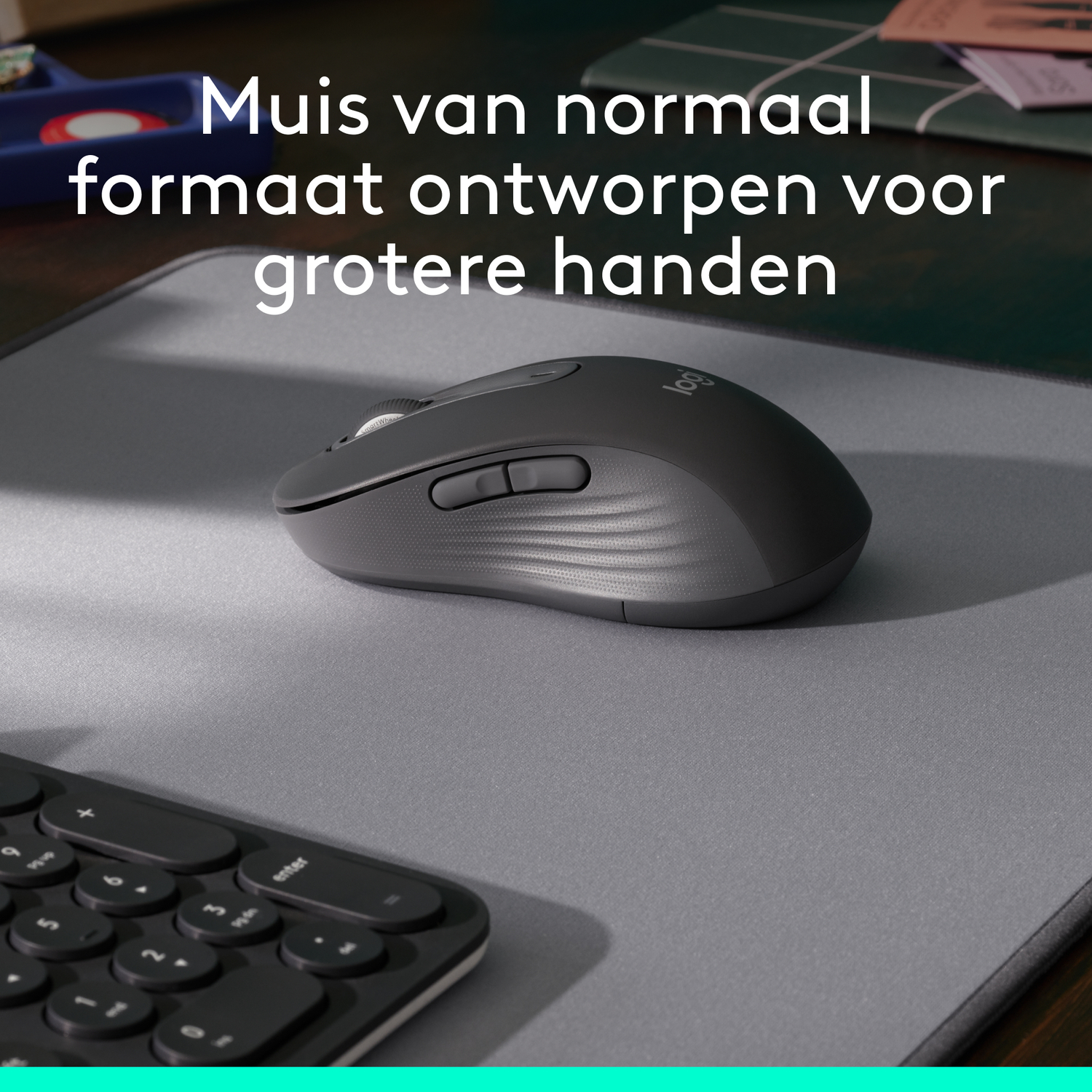 Zwarte Logitech-muis op een grijze muismat, met een toetsenbord op de voorgrond.