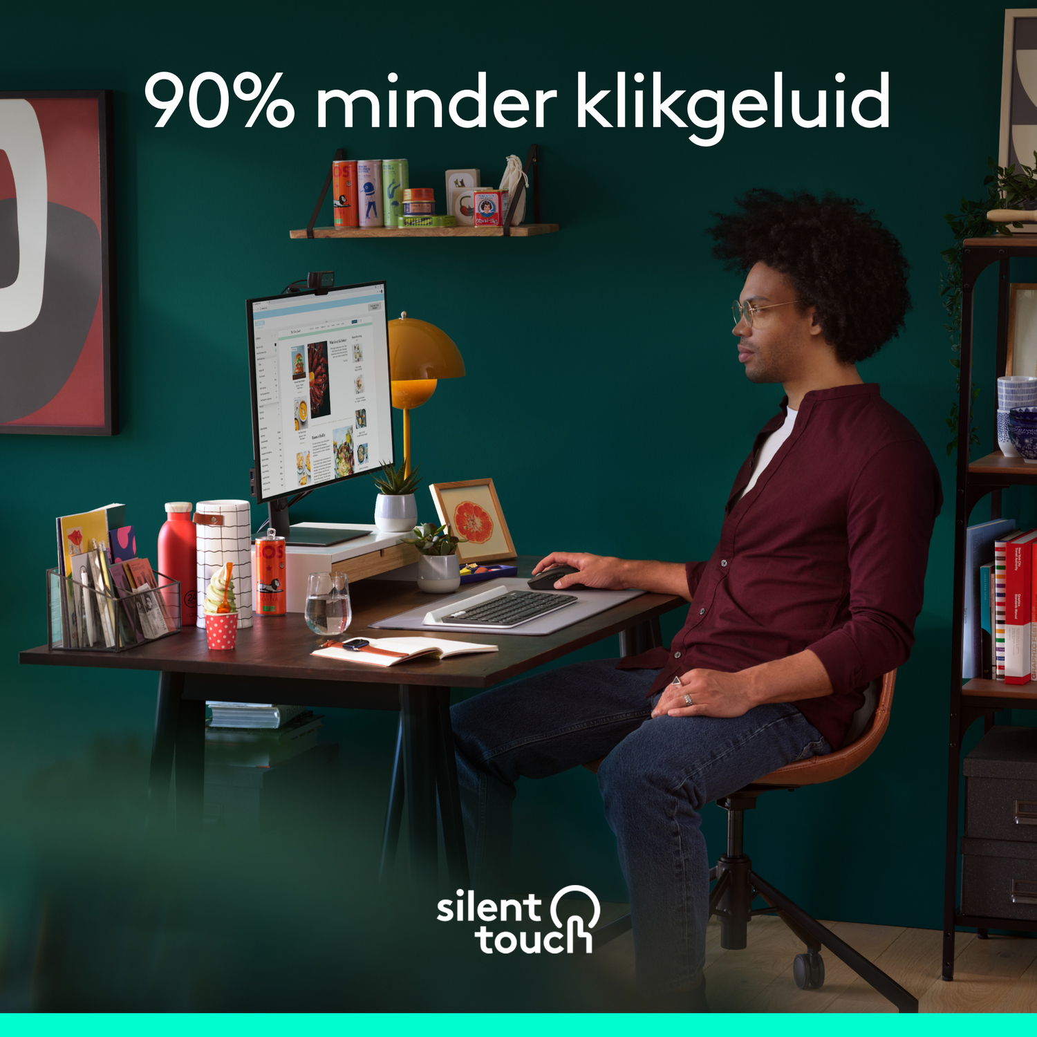 Man aan bureau met muis en toetsenbord. Monitor en accessoires zichtbaar. Tekst: 90% minder klikgeluid.